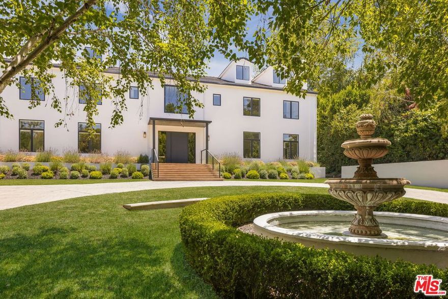 Behind gates and tall hedges South of the Boulevard, this celebrity-owned Encino estate spans over one acre. Fully renovated, the property welcomes you through grand gates and a spacious motor court to a main residence featuring a dramatic double staircase, multiple living areas, a private office, and a chef's kitchen that opens to the dining room and resort-style backyard. The basement level includes a state-of-the-art recording studio with its own private entrance. Upstairs, five en-suite bedrooms include a luxurious primary suite with dual closets, spa bath, and a terrace overlooking the grounds. Outside, enjoy a new pool and spa with waterfall and slide, a tennis court, putting green, covered dining patio with bbq area, fire pit, and a play area. A detached guest house offers a full gym, kitchen, and private guest quarters. A rare opportunity to own a secluded, resort-like compound in one of Encino's most coveted neighborhoods.