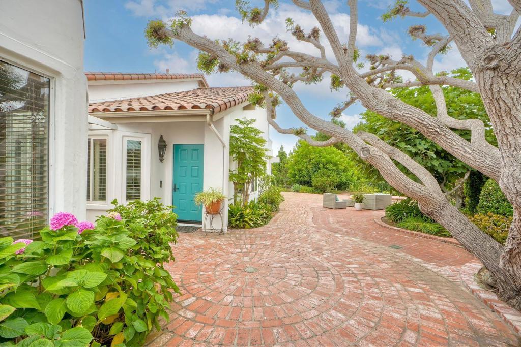 Discover this charming home (Bellagio floorplan), situated on an expansive, landscaped lot with breathtaking views of the golf course, rolling hills, and ocean beyond. This two-bedroom, two-and-a-half-bath residence is light and bright throughout, with French doors off the living room opening to a spacious brick patio and walkway. The outdoor living spaces are private, surrounded by lush, colorful landscaping—perfect for entertaining, relaxing with a morning coffee, or enjoying the spectacular sunsets. Inside, the main level features a generous primary suite, a large open living and dining area with soaring ceilings, kitchen with breakfast nook, and a separate office/den. Also on this level: a convenient laundry room, powder bath, and direct access to the two-car garage with built-in cabinetry providing ample storage space. Upstairs, you’ll find a second generous primary suite, a versatile loft, and a west-facing deck that captures ocean and sweeping sunset views. Located in the highly desirable 55+ resort-style community of Ocean Hills Country Club, this home overlooks several holes of the executive golf course. The gated community offers exceptional amenities, including a clubhouse, pool and spa, fitness facilities, tennis and pickleball courts, billiards, ping pong, and more. This beautiful home is priced to sell and ready for immediate move-in—or the perfect opportunity to update and design to your personal vision.