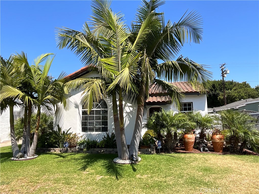 This is a Spanish-style home with Exceptional Charm in South Gate! Step into timeless elegance with this beautifully maintained Spanish-style residence, proudly nominated by the City of South Gate Council for the owners’ exceptional commitment to beautifying and enhancing their home and neighborhood. Rich in character and craftsmanship, this 3-bedroom, 2-bath gem seamlessly blends authentic architectural details with thoughtful modern upgrades, situated in a prime location near shopping plazas, freeways, and top-rated schools. The home makes a striking first impression with its classic Spanish tile roof, known for both its insulation benefits and timeless curb appeal. A stylish, solid embossed spiral metal entry gate complements a beautifully landscaped garden, adorned with King and Phoenix Roebelenii palm trees and garden accents. The tile floor and arched entryway lead to a custom dark brown print door and a welcoming chandelier that set the tone for the charm within. Inside, you’ll find original hardwood floors, white walls, and exposed dark wood ceiling beams that showcase the home's rustic Spanish charm. The spacious living room features a classic chimney fireplace—a perfect layout for both entertaining and everyday living. The spacious dining area allows for a large family dinner table. The primary suite features vaulted ceilings, an en-suite bathroom, and a walk-in closet, while two additional bedrooms share a fully remodeled hallway bathroom. The kitchen and cozy breakfast nook are warm and inviting, with a bonus side room ideal for a walk-in pantry or future expansion. Additional upgrades include: new galvanized plumbing throughout the entire home, a remodeled bathroom with updated fixtures and finishes, and a beautiful garden design with mature palms and tile-accented walkways. This is a rare opportunity to own a Spanish-style home with potential to convert the garage to an ADU. This is a true South Gate treasure. This home is move-in ready, must see. Home will be sold in "as-is" condition.