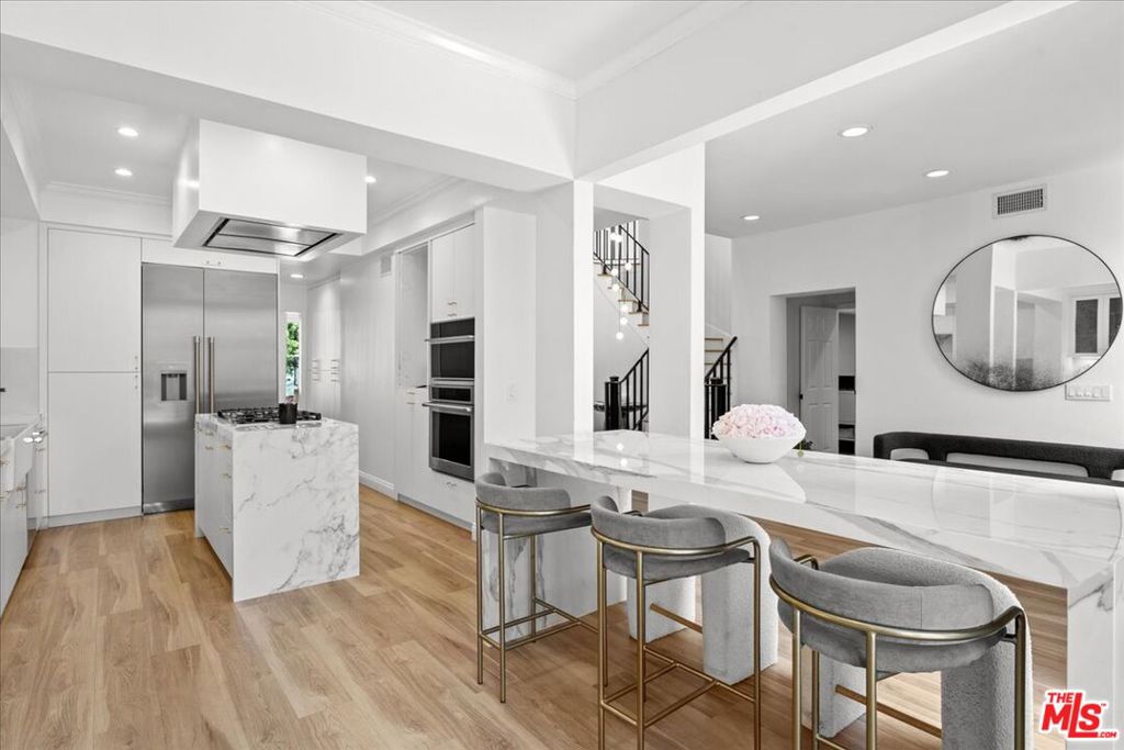 Set within the prestigious guard-gated Ridge community in MountainGate, this beautifully remodeled townhome combines elegant design with modern comfort. Offering 3 spacious bedrooms and 4 baths, it features fine marble finishes, a bright open floor plan, and curated designer details throughout. The double-height living room makes a stunning first impression, highlighted by a dramatic custom staircase and beautiful custom wine storage. A large formal dining room and eat-in kitchen with stainless steel appliances open to sweeping mountain and city views perfect for entertaining or relaxed everyday living. Step outside to a stylish back patio with fountains and expansive views an ideal setting for hosting dinner parties or enjoying evenings under the stars. The oversized primary suite boasts panoramic views, a luxurious soaking tub, dual vanities, and a grand custom marble shower. Both upstairs bedrooms include dual vanities and ensuite baths. Additional features include a separate laundry room and access to MountainGate's exceptional amenities, all within a 24-hour guard-gated community with patrolled security.