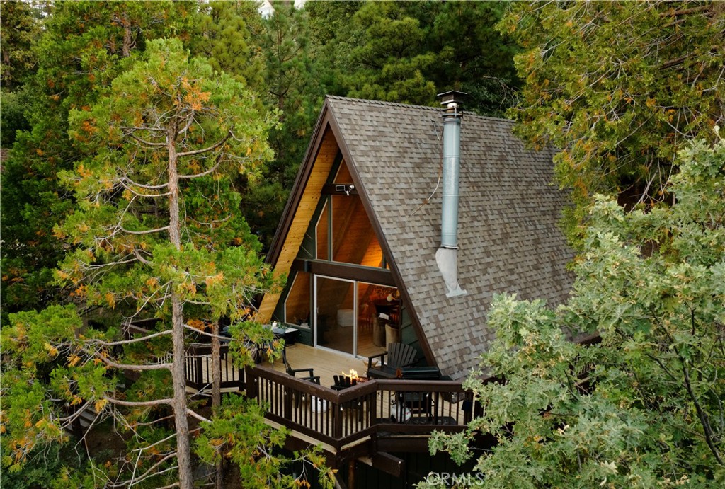 The A-Frame everyone’s been looking for...
With panoramic views, a wall of glass, and a fresh interior update, 842 Nadelhorn checks all the boxes for a true mountain escape.
Set above Lake Arrowhead and surrounded by towering pines, this three level home was thoughtfully remodeled in 2023 with clean finishes and a layout that makes the most of the setting. On the main level, you’ll find cathedral ceilings, a cozy wood burning fireplace, and open living that flows out to a wraparound deck, perfect for grilling, lounging, or enjoying the treetop and peekaboo lake views. The kitchen was refreshed with new cabinetry, tile, appliances, and plumbing. A bedroom and full bath on this level make for easy, no stairs access.
Upstairs is a private loft style ensuite with a tucked away desk area and some of the best ridgeline views in the house.
The lower level adds even more space, with a second living area, a bunk room with arcade games, another bedroom, full bath, laundry, and a seperate entrance that leads to a private side yard and hot tub, the ideal spot to unwind under the stars.
The design blends warm earthy tones with a touch of mid century modern, perfectly suited to its mountain setting. Whether you’re cozying up by the fire or heading out to explore, this home blends comfort and style in all the right ways.
Currently a successful short term rental with Airbnb’s “Designer” status, with lake rights included and just minutes from the Village, trails, and more, this is the A-Frame you don’t want to miss.