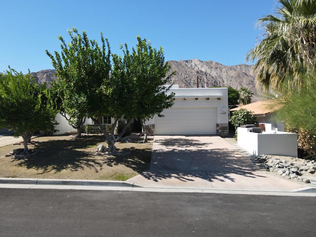 Experience desert living at its finest in this charming Santa Fe-style home nestled in the coveted La Quinta Cove. Surrounded by breathtaking mountain views, this single-story residence features 3 bedrooms, 2 baths, and 1,494 sq. ft. of open living space designed for comfort and style. The light-filled interior showcases high ceilings, clerestory windows, and beautiful terracotta tile flooring throughout. The spacious living area includes a cozy fireplace and direct access to the private backyard retreat. The kitchen offers granite countertops, white cabinetry, a breakfast bar, and a cheerful dining area with plantation shutters. Step outside to your own private oasis featuring a sparkling pool, sun patio, and covered pergola perfect for dining or entertaining under the desert sky. Additional highlights include an attached two-car garage, central HVAC, and a serene setting just minutes from Old Town La Quinta's shops, dining, and hiking trails. Ideal as a primary residence, seasonal getaway, or investment property, this home combines warmth, character, and the relaxed elegance of desert living.