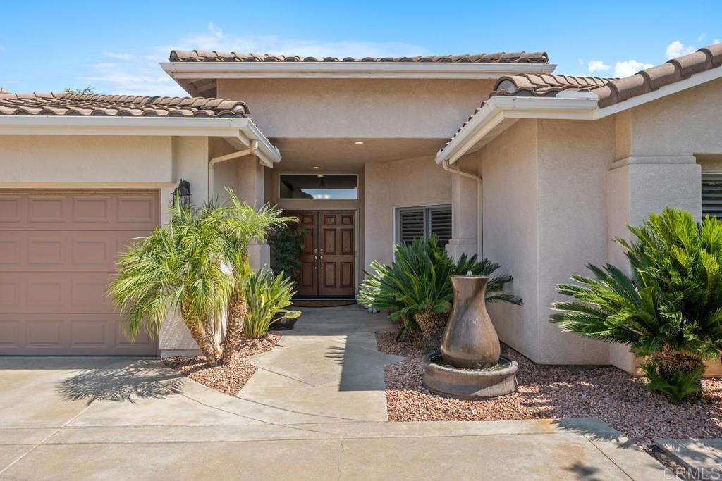 Welcome to Montclair—a highly sought-after Southwest Escondido community known for its convenient location near shops, restaurants, golf, Lake Hodges, and cultural venues, all with quick access to freeways and just 30 minutes to the coast or airport. This exceptional residence has been thoughtfully upgraded throughout. A flexible 4th bedroom now serves as a grand piano music room, while the spacious primary suite features backyard views, direct patio access, and a beautifully remodeled bath with quartz counter tops, designer lighting, a large walk-in shower, and dual closets. Outdoors, professionally designed gardens and lush landscaping create a serene oasis. The Alumawood patio cover provides shade from the sun and shelter from rain, setting the stage for year-round outdoor living and entertaining. Located on a quiet cul-de-sac, the home is set back from the street to offer privacy and tranquility.