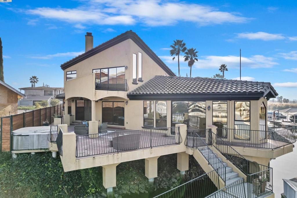Discover waterfront living in the heart of Discovery Bay, where luxury and relaxation meet. Whether you’re seeking a serene retreat, a hub for water activities, an Airbnb investment, or a stunning home with panoramic views, this property delivers it all. Located just minutes from fast water and boasting desirable Eastern exposure, it’s a rare find. The open-concept design is perfect for entertaining, featuring elegant red oak flooring, a large wine fridge, electric shades, a hidden projector with a 126” screen, built-in speakers, and a secret room accessed through a concealed bookcase. The chef’s kitchen is a showstopper, equipped with a 48-inch WOLF range, Viking refrigerator, custom maple cabinetry, granite countertops, a prep sink island, pantry, bay window, and a reverse osmosis system. The primary suite offers breathtaking water views, open-beam ceilings, mirrored closets, a private balcony, and a gas fireplace with built-in speakers. Its spa-like bathroom includes a jetted tub, walk-in shower, bidet, heated floors, and a boutique closet with custom built-ins. The home’s exterior windows are mirrored, providing added privacy while enhancing the sleek, modern aesthetic. Additional features: 4 boat slips, hydro hoists, solar, and trex dock.