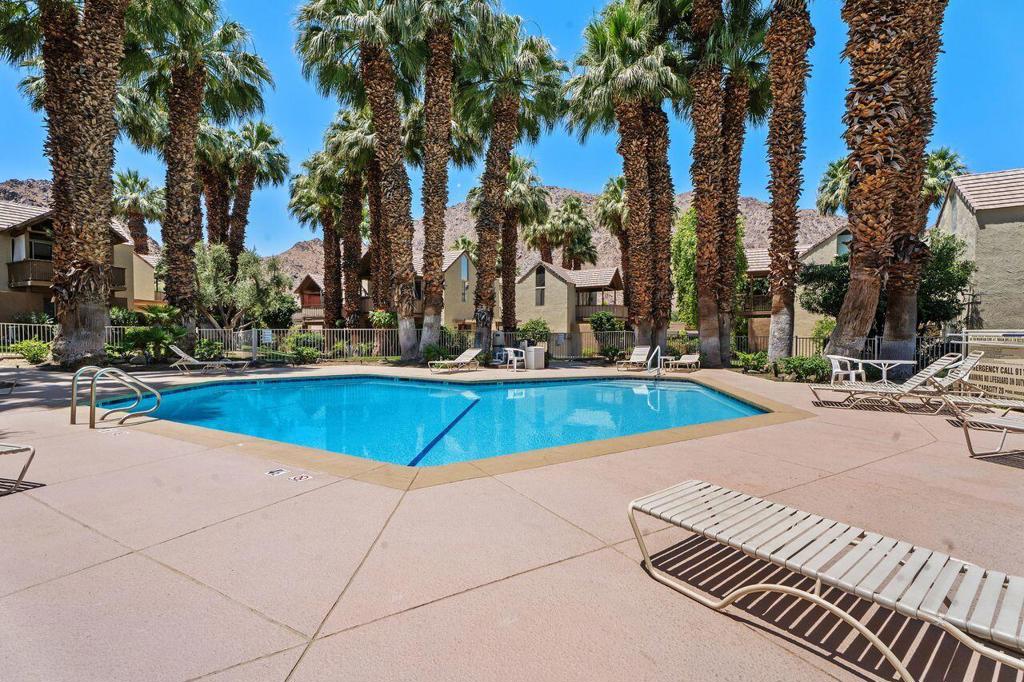 Presenting a rare ground-level condominium situated on fee land in highly sought-after Indian Wells. Located within the secure, guard-gated Mountain Cove community, this fully furnished 2-bedroom, 2.25-bath residence offers exceptional resort-style living and outstanding income potential. The open floor plan features two spacious en-suite bedrooms, including a separate-entry lock-off suite equipped with its own air conditioning unit and water heater, providing added rental versatility. Expansive sliding doors lead to a generously sized wraparound patio with captivating mountain views, just steps from the beautifully landscaped community pool. This property allows for short-term rentals (minimum 7 days), affording flexibility to lease the lock-off, main suite, or the entire unit as needed. Ideal as a vacation retreat, investment property, or full-time residence, it also benefits from IID electric rates and meticulously maintained grounds. Residents enjoy exclusive Indian Wells privileges, such as a 20% discount on dining and spa services, as well as preferred golf rates at the renowned Indian Wells Golf Resort. This is an exceptional opportunity to combine lifestyle and income in one of the desert's most desirable locations.