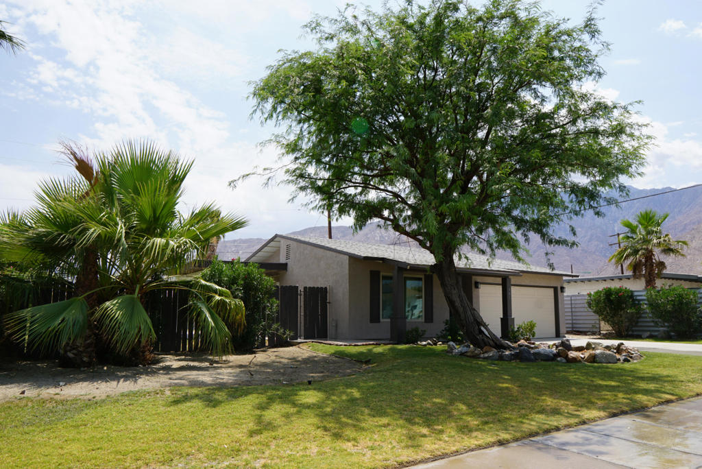 Freshly updated single-family home with 4 bedrooms and 2 bathrooms in Palm Springs's Desert Highland Gateway Estates neighborhood. Features include new interior paint and carpet, tile flooring throughout the main living areas, carpeted bedrooms, and an upgraded galley-style kitchen with granite countertops, soft-close cabinets, and stainless steel appliances. Primary bedroom includes its own full bathroom, mirrored closet, and private patio. Interior laundry closet. French doors in the dining room lead to a large landscaped yard and covered patio. Attached two car garage with newer opener and fresh concrete paint.