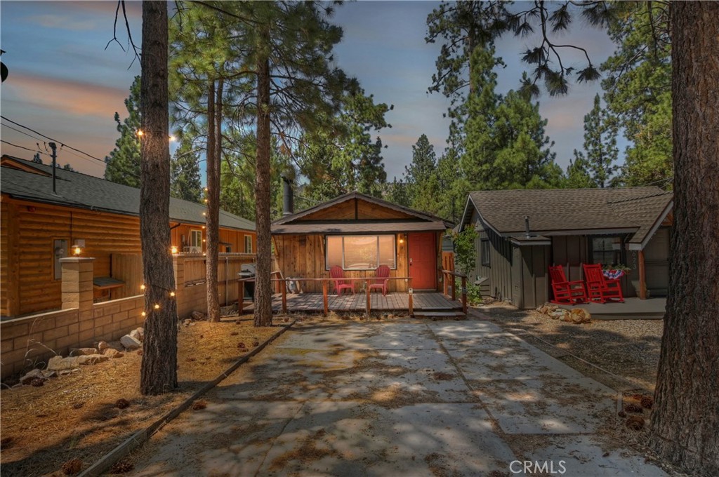 This charming, fully furnished 2-bedroom, 1-bath cabin is the perfect blend of rustic charm and modern comfort—ideal as a personal mountain getaway or income-producing short-term rental. With a successful vacation rental history and excellent reviews, this property is truly turnkey and ready to enjoy or generate income from day one. Step inside to find a bright and inviting layout featuring an updated kitchen and bathroom with sleek quartz countertops and a stylish glass tile backsplash. The open galley-style kitchen flows seamlessly into a spacious living room anchored by a cozy rock-faced wood-burning fireplace, perfect for relaxing evenings. The cabin also features dual-pane windows throughout, a mini-split system for heating and air, and central heat for year-round comfort. Both bedrooms are generously sized with large windows that let in abundant natural light, creating an open and airy feel. Outside, enjoy a large front deck ideal for BBQs and entertaining, plus a flat, level lot with a concrete driveway for ample off-street parking and a storage shed in the backyard. Whether you're looking for a serene second home or a proven income property, this adorable cabin checks all the boxes—fully furnished, beautifully maintained, and ready for your next adventure in the mountains.