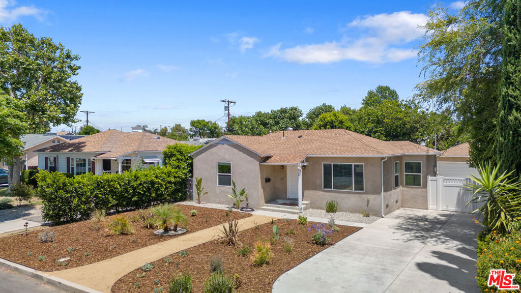Experience this beautifully renovated three-bedroom home in the heart of the San Fernando Valley, thoughtfully positioned behind a generous front garden on a tranquil residential street in Lake Balboa. The home's open floor plan creates effortless flow between spaces, with abundant natural light filtering through energy-efficient windows that frame views of the spacious outdoor areas. At the heart of the residence, a well-appointed kitchen anchored by a central island and quartz countertops opens naturally to the living and dining areas, encouraging both intimate gatherings and larger entertaining. The primary suite provides a private retreat with ensuite bathroom and substantial walk-in closet, while two additional bedrooms offer comfortable accommodations for family or guests. Plus dedicated laundry room. A new gate separates the front and back yard, providing gated rear off-street parking for added convenience and privacy. Multiple connections link the interior spaces to the rear yard, where a lush lawn enclosed by mature landscaping creates a serene outdoor environment. Practical amenities include generous driveway, detached two-car garage with ADU potential, and new AC maintains a comfortable year-round climate, while the location offers convenient access to Valley dining, recreational fun at sprawling Balboa Park, and easy access to the 101 and 405 freeways allow seamless connection to beaches and all of LA.