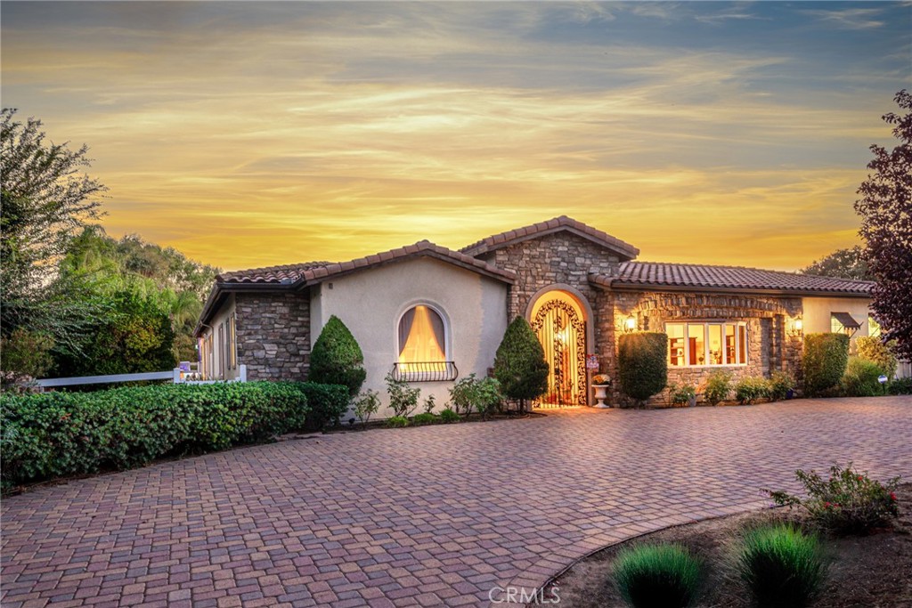 **Experience the Essence of Tuscan Elegance in Murrieta**
Welcome to this exceptional single-level, custom-built Tuscan estate offering 4 bedrooms, 3 full baths and 2 .5 bathrooms, and an entertainer’s dream backyard. Perfectly situated on a fully usable .91-acre lot, this residence blends timeless European charm with modern luxury.
A private, gated courtyard with an outdoor fireplace and fountain creates a warm and inviting entry. Just off the courtyard, a separate guest suite offers complete privacy and comfort—ideal for extended stays. Inside, sophisticated living spaces include a formal dining room and a gracious living room, both with French doors that open to the expansive covered patio.
The heart of the home is the gourmet chef’s kitchen, featuring newer stainless-steel appliances, an oversized refrigerator, walk-in pantry, and a seamless flow into the spacious great room. The primary suite is a private retreat, complete with a sitting area, spa-inspired bath, walk-in closet, and direct access to a secluded outdoor space.
Every detail has been thoughtfully curated, from designer finishes and custom painting to the authentic Tuscan-inspired architecture. Outdoors, the resort-style setting includes a custom saltwater pool and spa, fire pit, and a fully equipped covered entertainment pavilion with BBQ island—perfect for hosting unforgettable gatherings. A detached pool house further enhances the lifestyle.
Practicality meets luxury with dual garages, a large U-shaped driveway, paid solar with 36 panels, and three recently installed AC units. The property is fully fenced with a security gate and offers ample space for RV parking, horses, or additional structures.
All of this is set in a coveted west side Murrieta location, within walking distance to schools and the charming shops and restaurants of Old Town. With low taxes and no HOA, this estate is as smart as it is stunning.