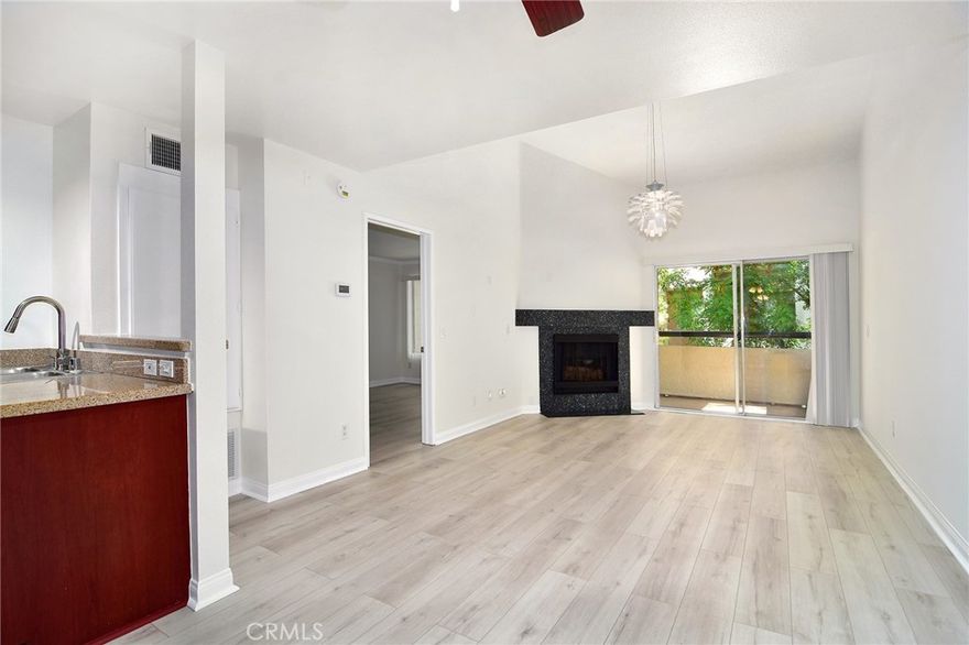 Resort style living in the heart of Warner Center, welcome to The Met! Located in one of the most desirable locations within the community on the top floor with NO SHARED WALLS, this penthouse corner unit is truly one of a kind! Immediately upon entering, you're mesmerized by the soaring high ceilings, fresh coat of paint and brand new luxury vinyl wide plank flooring. A wonderful open floor plan allows for open views from anywhere in the unit. A sizable living room with charming gas fireplace which also features a slider to your private balcony. An upgraded kitchen to include granite counter tops, stainless appliances and full size side by side refrigerator equipped with ice & water dispenser. The bedroom is surprisingly spacious and offers all new window treatments as well as an en-suite bath. The Met is a guard gated community that offers 4 resort-style swimming pools, six lighted tennis courts, full fitness center, racquetball and indoor basketball courts, multiple spas & endless amounts of guest parking. Don't forget guard gated and 24 hour security. All this located within walking distance to The Village, Warner Center Park and all the dining, shopping & entertainment Warner Center has to offer.