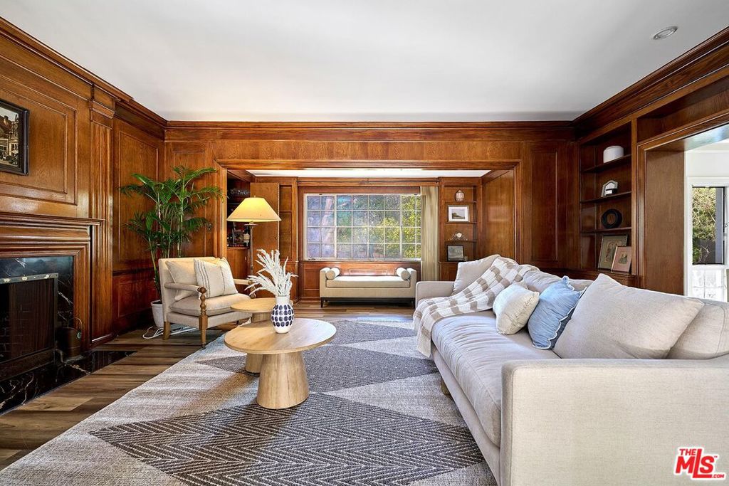 Presenting a fabulous estate in one of LA's most coveted and architecturally rich neighborhoods. This Colonial Revival residence in prestigious Windsor Village HPOZ is a true showcase of timeless design. An elegant foyer welcomes you into the grand living room with a decorative fire place, where oversized windows flood the space with natural light. The exquisite family room features original character details with rich woodwork, custom built-ins, a hidden wet bar, a marble fireplace, expansive windows and a French Bay Door leading to the enclosed patio with a wet bar and a powder room. A guest suite with a private bathroom is connected to the laundry room off kitchen. The upgraded kitchen connects to a charming breakfast room and a spacious formal dining room. Upstairs, the spacious primary bedroom with an en-suite bath, walk-in closet and large windows is bathed in natural light. Three additional bedrooms share a Jack-and-Jill bathroom, along with a private balcony overlooking the backyard for enjoying morning coffee.Outdoor amenities include a tree-filled backyard, a romantic front garden with a gazebo, and a detached two-car garage. Step into the backyard and discover a fantastically spacious resort-like retreat with BBQ and green house for family gathering and entertaining. Tall trees around the house and metal gate offer privacy and security.Adjacent to Hancock Park, Larchmont Village, Harold Henry Park, The Ebell Theater, The Grove and convenient access to shops, dining, and the upcoming Purple Line on Wilshire Blvd. Sitting on a 10,480 square feet lot of LAR3, this home offers incredible potential for a variety of possibilities.