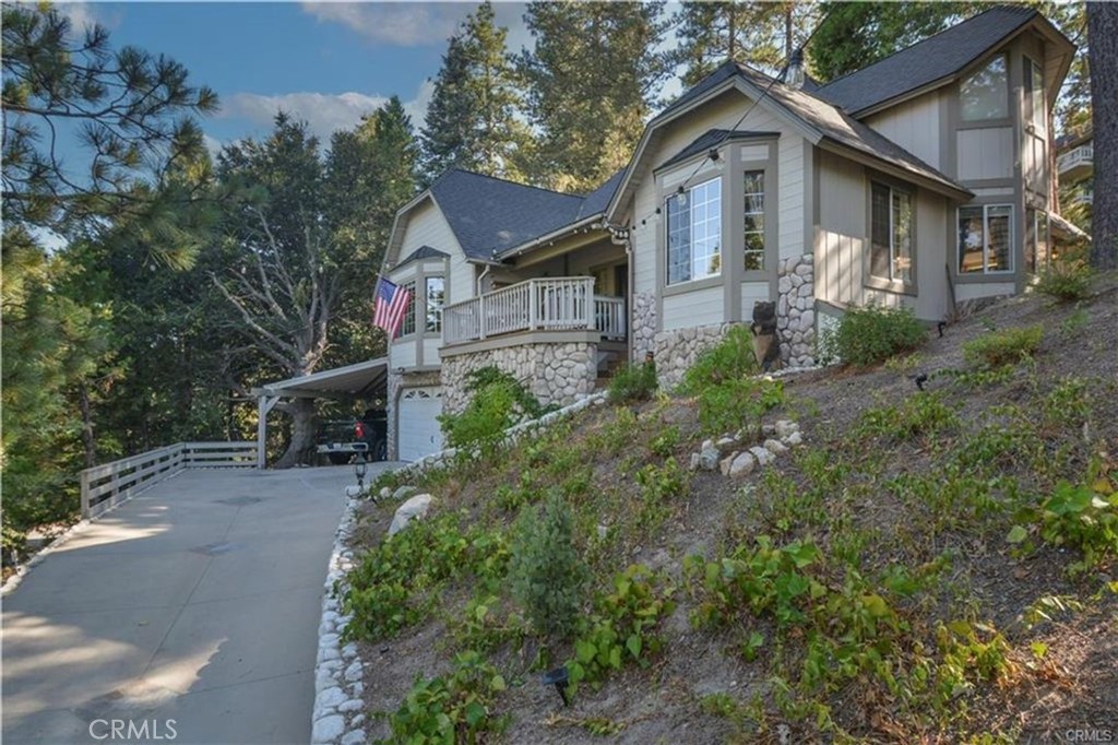 Charming Mountain Retreat offering a cozy and inviting atmosphere. Enter an impressive stone stairway surrounded by landscaping to a front porch. As you walk through the front door to an entry on the main level you find the living room with its vaulted beamed tongue and grove ceilings and a focal point fireplace with its floor to ceiling rustic stacked stone with bold wood mantel and frame. French doors open from this stately but cozy living room to a large private deck. On this main floor you also have the formal dining room, two bedrooms, (one has a built-in desk and cabinets-owner willing to remove), a full bath and Kitchen. The updated Kitchen has top of the line stainless appliances, granite counters and tumbled marble backsplash, spacious enough for the family to enjoy with room for a large eating area. Upstairs is a large main en-suite bedroom with 2 closet areas, one a wall of mirrored sliders the other is a walk-in closet, the large bathroom has dual sinks, a Jacuzzi tub and shower, there is also another room currently used as a sewing room but could be office/sitting room so many options. Outside you'll find whimsical pathways that lead to the backyard and private access road great for strolling and enjoying the forest. Parking is no problem with its attached 2 car garage, a carport for two more vehicles and long enough driveway for a couple more. Plenty of room for the whole family. To add to all this charm there is also; dual air conditioners, a whole house generator, an extra storage shed off the kitchen and LAKE RIGHTS!