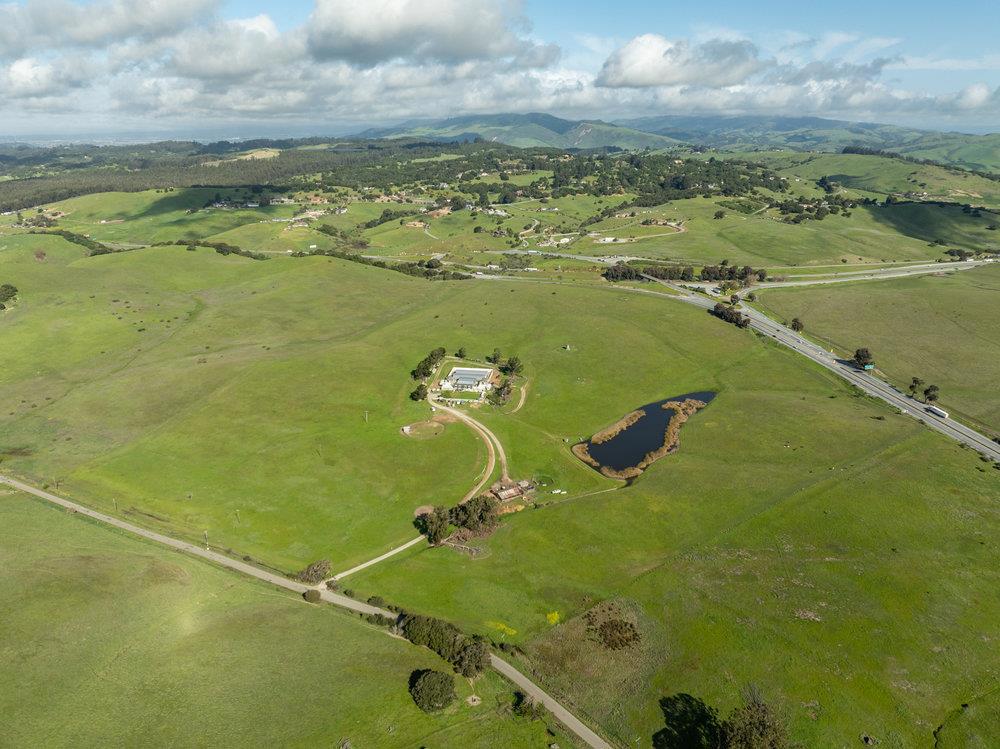 Welcome to 600 Rocks Road in San Juan Bautista, truly unique property nestled on approximately 70 acres of gorgeous rolling hills with 5 acre zoning. The 7,020 sq. ft. home features 2 bedrooms, 2 bathrooms, and numerous utility spaces, offering endless possibilities for creative living. Once used as a dog kennel, this distinctive residence invites you to reimagine its charm. The expansive grounds include a serene year-round pond, four domestic wells, a barn, and multiple greenhousesone boasting a durable concrete floor. Additionally, the property is conveniently located near Hwy 156 and Hwy 101, ensuring quick and easy access to both the Bay Area and Monterey Bay. Embrace the blend of rustic beauty, modern potential, and unbeatable location at this exceptional property.