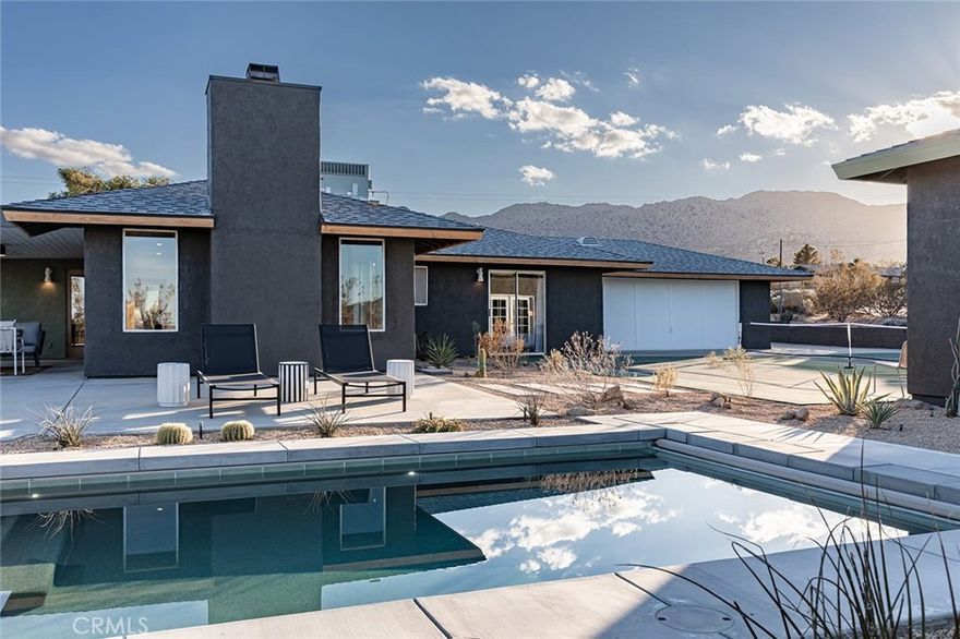 Mojave Paddle Club: Meticulously designed home & grounds featuring a custom pickleball court and in-ground pool & spa (with automatic retractable cover). STR earning are approximately $100k gross over the previous 12-months. The interior – thoughtfully laid out by Studio Collab Designs – features an open-concept floorplan with high-end furnishings, décor and materials sourced from renown brands such as Bedrosians, Fireclay and Zia Tiles. Turnkey/Fully furnished interior - including a custom Interior Define sofa, a dining room table from Burke Decor & another dining room table from Inside Weather, in addition to high quality Tuft & Needle mattresses, Floyd Bedframes to name a few. Pet friendly fully-fenced backyard. Mojave Paddle Club has been featured in Palm Springs Life Magazine. Currently used as a vacation getaway and vacation rental, this spacious home comfortably sleeps up to eight guests in three rooms. The kitchen, dining and living area compose one wing of the house with a third room set up to be utilized as an office, game room, or additional bedroom. Primary bedrooms are located at the opposite end to allow for privacy and sleeping while other stay up socializing. The primary bedrooms showcase exquisitely tiled bathrooms and private access to the court and pool. Back out in the living area, relax by the wood burning fireplace or retreat to the yoga room out back. The expansive kitchen area is fully equipped and offers views of the outdoor patio, pool, and pickleball courts. A table for six in front of the fireplace provides an ideal space for formal dining or casual gatherings. Or enjoy meals al fresco near the propane BBQ and outdoor dining area. Fully remodeled and updated inside and out, new surfaces everywhere and new systems, including an efficient central HVAC. Smartly landscape with drought resistant vegetation. Dark nights perfect for stargazing from the spa. Minutes to the downtown Farmers Market or the front gate to Joshua Tree National Park just up the road. Come visit this exquisite resort-like ambiance today.