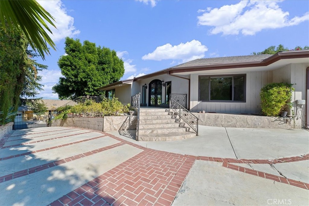 Luxury Live Auction! Bidding to start from $1,800,000! Nestled in the prestigious Royal Oaks neighborhood of Encino, this single-story gated mid-century home sits on a generous 16,041 sq. ft. corner lot on a tranquil cul-de-sac. Offering 3,570 sq. ft. of living space, this property presents an exceptional opportunity for investors or developers. With breathtaking views, there is potential to remodel and upgrade the existing home, expand the outdoor space with a deck to further enhance the view, or even tear down and build a magnificent estate. The expansive open-concept great room seamlessly blends the living room, family room, and dining area, all featuring elegant porcelain tile flooring. The kitchen is designed with granite countertops and a spacious eating area. The home includes four bedrooms, all with hardwood floors, and three bathrooms. Two bedrooms share a Jack and Jill bath, while a separate fourth bedroom is conveniently located next to a ¾ bath. The primary suite boasts a walk-in closet and a spa-like bathroom with dual vanities and a sunken terrazzo tub. The private backyard, complete with a pool, provides the perfect setting for relaxation and entertaining. Ideally situated in the sought-after Lanai Road Elementary and Hesby Oaks Middle School districts, the property is also just moments from Ventura Boulevard’s vibrant shops and restaurants, with easy access to freeways and the Westside.