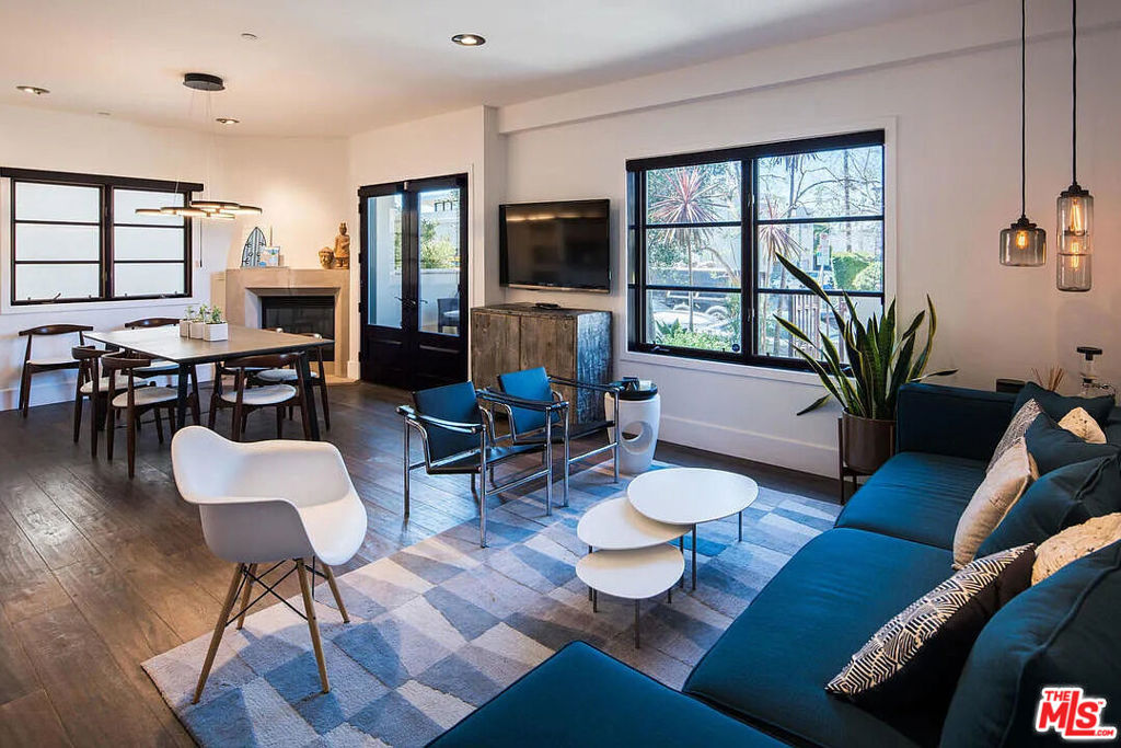 Contemporary 3-bedroom, 2.5-bath unit with designer finishes and upgrades throughout. Features an open-concept kitchen, living, and dining area with a fireplace, plus a large private patio. Includes extra storage, secured parking with guest parking, and a sun deck with city and mountain views. Centrally located in West Hollywood.