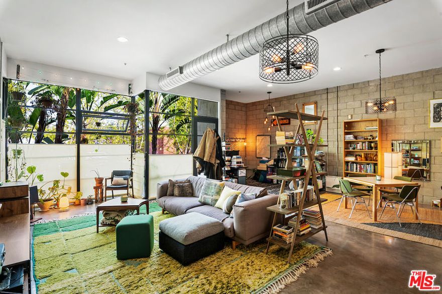 Designed by acclaimed architects Pugh + Scarpa, this Santa Monica live-work loft seamlessly combines style and practicality. Situated in the heart of the city, itoffers an open floor plan with exposed steel beams, polished concrete floors, and expansive floor-to-ceiling windows that flood the space with natural light. The kitchen is equipped with premium stainless steel appliances, a spacious center island, and custom cabinetry. The living area opens up to an east-facing patio. This loft includes one bedroom and two full bathrooms, with the primary suite featuring a luxurious ensuite bath with a large shower and dual vanities, along with generous storage and closet space. A fully functioning garage door in the bedroom adds a unique touch, providing a seamless indoor-outdoor experience. Additional amenities include in-unit laundry, side-by-side garage parking, guest parking, and secure building entrance.