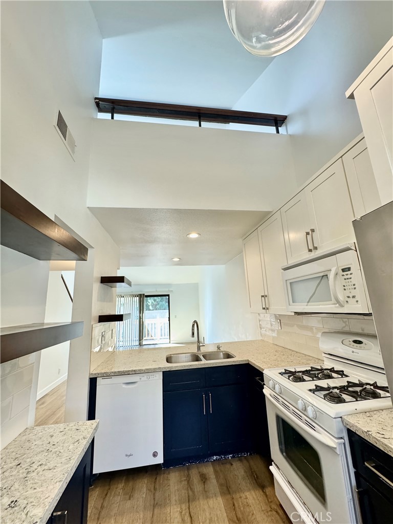 This bright and airy upper-level unit offers cathedral ceilings with serene views of a peaceful stream, framed by mature trees that provide natural privacy. Thoughtfully remodeled several years ago, the home features 1 bedroom, 1 bathroom, and a versatile loft—perfect for a home office or optional second bedroom.
Stylish vinyl flooring flows throughout the living room, kitchen, and bedroom. The unit includes central A/C and a convenient in-unit stackable washer and dryer tucked away in a closet off the bedroom.
The kitchen is equipped with a gas stovetop and quartz countertops with self-close drawers, a microwave, stove, and refrigerator. Located in the desirable Orange Tree community, residents enjoy access to a wide array of amenities including a pool, spa, fitness center, tennis and pickleball courts, basketball courts, a clubhouse, and BBQ areas ideal for hosting larger gatherings.