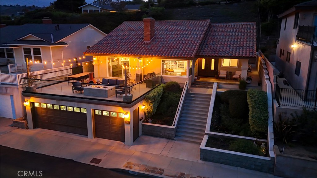 For the discerning buyer seeking a refined, low-maintenance coastal lifestyle, this Mediterranean-inspired villa delivers on every level. Nestled on a quiet cul-de-sac in the coveted Upper South Shores, the home enjoys unobstructed ocean and Catalina Island views from nearly every main living space. Cool afternoon breezes complete the relaxed, elevated feel of this special property. Completely reimagined with a focus on quality, this home offers timeless sophistication. It’s not for someone chasing fleeting trends—no stark whites or grays here. Instead, rich natural finishes and craftsmanship take center stage. Designed for those who value elegance and ease over excess outdoor space, this residence is effortless coastal living at its finest. Curb appeal is instant. A wide stone staircase leads through lush, manicured landscaping to a covered front porch trimmed in natural stone. Smooth stucco, a red tile roof, and patina copper accents complete the classic Mediterranean exterior. Through the double-door entry, you’re welcomed by soaring 10-foot ceilings and a large coat closet in the foyer. The formal living room features vaulted ceilings, a natural stone fireplace, built-in bookshelf and a large picture window showcasing panoramic views. An arched opening leads into the formal dining area and the upgraded kitchen, outfitted with custom wood cabinetry, granite countertops, walk-in pantry, and a travertine backsplash. Stainless steel appliances include a six-burner cooktop, counter-depth refrigerator, double oven, dishwasher, and custom hood. The adjacent family room offers a second fireplace, attractive tray ceiling, and sliding glass doors that open to a 600+ sq ft deck. With frameless glass railings and jaw-dropping views, it’s an ideal spot to relax or entertain. The private wing includes a spacious primary suite and two additional bedrooms, all with vaulted ceilings, wide-plank hardwood floors, and generous closets. Both bathrooms feature natural stone, granite, and custom cabinetry. A large indoor laundry room adds ample storage, a utility sink—and even an ocean view. Crown molding, Baldwin hardware, designer lighting, recessed lighting, and a spotless three-car garage complete this truly special home.