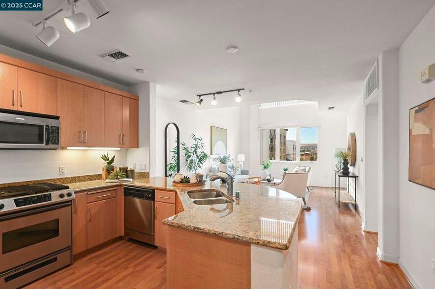 Discover urban living at its finest in this stunning 2-bedroom, 2-bathroom condo, perfectly located just minutes from Dublin BART, shopping, dining, and easy freeway access to 580/680. Boasting an impressive 1,399 sq. ft. two-level layout with soaring vaulted ceilings, this home blends space, style, and convenience. The open-concept living and dining area features beautiful laminate flooring, recessed and track lighting, and a private balcony with breathtaking mountain views. The gourmet kitchen is a chef’s dream with granite countertops, stainless steel appliances—including a double-door refrigerator and gas range—plus a double basin sink with pull-out faucet.  The luxurious primary suite offers a large walk-in closet and spa-like bath, while the second bedroom and full bath provide flexibility for guests or a home office. Additional highlights include in-unit front-loading washer/dryer, central heat and A/C, and two secure parking spaces in a gated garage.  Enjoy resort-style amenities—fitness center, game room, social lounge, and lush landscaped courtyard—all in a prime Dublin location where everything is within reach.  Welcome home to luxury, location, and lifestyle!