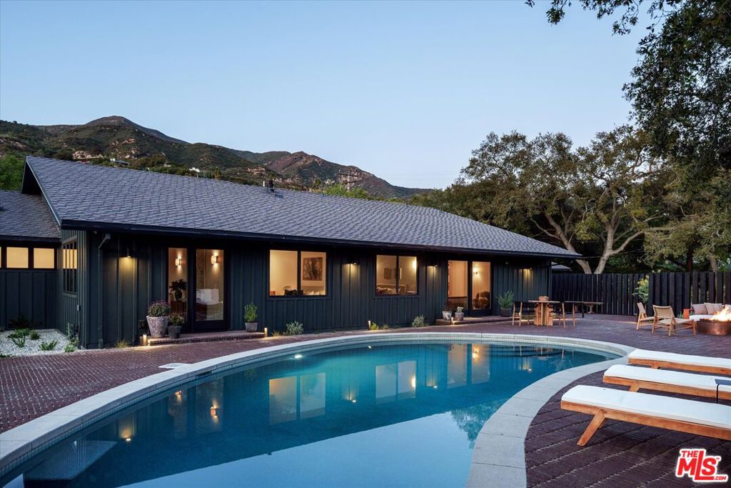 Set against a spectacular mountain backdrop in Montecito's coveted Cold Spring School District, this thoughtfully designed 4-bedroom, 3-bathroom residence is nothing short of a retreat. Situated on an expansive 1.22-acre parcel, the home effortlessly blends sophistication with its serene surroundings. Upon arrival, lush landscaping designed by ORCA Living welcomes guests, complete with winding paths, mature olive trees, native plants, and verdant hedging. Inside, carefully positioned windows seamlessly connect the indoors with nature, offering picturesque views of the mountains, gardens, or the shimmering pool and south-facing grounds from every room. The living room features dramatically vaulted ceilings, capturing some of the home's most breathtaking views, and is anchored by an elegant Beaumaniere Limestone fireplace an ideal setting for formal gatherings or tranquil evenings. A secondary living space, warm and inviting, offers direct access to the backyard and pool, perfect for more relaxed entertaining.A majestic California Live Oak and sparkling pool serve as the centerpiece of the backyard, which offers abundant space for outdoor enjoyment, including dedicated areas for alfresco dining, relaxing by the fire pit, and playing on the expansive grassy lawn. Additionally, a detached bonus structure provides versatile space perfect for a home gym or private office. The kitchen boasts top-of-the-line Thermador appliances, luxurious Calacatta Viola surfaces, and dining table with banquette, maintaining excellent natural light throughout the day, as with the adjoining dining room. The spacious primary suite features sliding glass doors that open directly to the pool area, complemented by a luxurious ensuite bathroom with heated floors, Calacatta Paonazzo surfaces, Travertine tile, and an expansive closet. Additional bedrooms include one with floor-to-ceiling custom bookcases and a private outdoor sitting area, as well as two comfortable interior bedrooms with serene views of the pool and back yard. This meticulously renovated property presents a rare opportunity to own a refined retreat in the heart of Montecito.