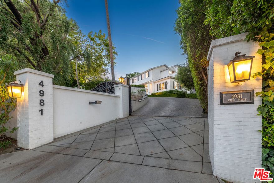 BEST PRICED NEWER CONSTRUCTION IN TARZANA! Former home of international music superstar Marc Anthony. This amazing Hampton's Style Traditional was built in 2014 when quality was king. Gated, hedged and set on its own over 1/2 acre private knoll with views of mountains, valley lights and verdant treetops, this ultra private estate is ready for its next lucky owner. The gated motor court is perfect for car collectors accommodating approx a dozen cars plus a rare 4 car side-by-side garage. The gracious formal entry introduces the home replete with walnut toned wood floors, white walls and the ideal floor plan. The 5 bedroom 6.5 bath estate offers over 6,500 sq ft of luxury living and includes an upstairs home office as well as a true gourmet's kitchen with double Calcutta marble center islands, honed quartz counters, herringbone tiled backsplash, Wolf range with double oven, Sub Zero R/F, breakfast bar and separate breakfast room all open to the family/media room with fireplace. A formal living room and dining room are also adjacent to another media/den space ideal for a screening room with access to the outdoor kitchen BBQ island, full sized pool/spa, Gazebo viewing pavilion and multiple living/dining areas. Upstairs are 4 generous en-suite bedrooms including the primary suite with a stunning closet, spa-style marble bath with soaking tub, a separate Junior primary suite, 2 additional suites and a home office. Downstairs is a guest suite as well. This is truly a step above most newer construction homes offering no street visibility and the chance to live in your own world high above the rest yet easy access to Ventura Blvd shops, restaurants and houses of Worship. Come live your best life at 4981 Amigo.