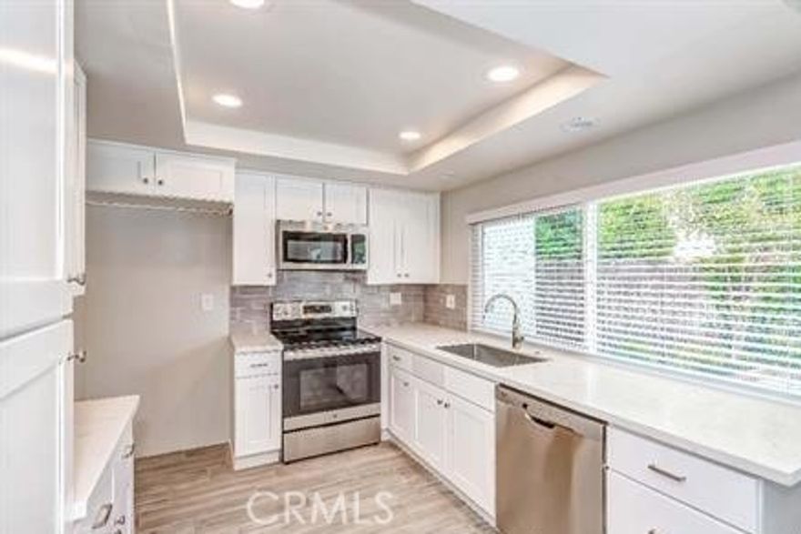Beautifully remodeled single-story home in the desirable Los Coyotes Country Club area. Move-in ready, this 3-bedroom, 2-bath residence features an all-electric kitchen with granite countertops, white cabinetry, updated fixtures, and stainless steel appliances. The spacious family room is adjacent to the kitchen—perfect for gatherings and everyday living. Interior upgrades include new laminate and tile flooring throughout. Both bathrooms have been fully updated with new vanities, lighting, and tile finishes. The primary suite offers double sinks, a remodeled shower, and modern design touches. Additional highlights include a 2-car attached garage and a convenient location near parks, markets, and the Los Coyotes Country Club and golf course.