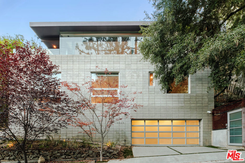 Designed and built by the award winning architectural firm Tag Front, this sophisticated Beverly Hills hideaway offers a one of a kind modern retreat on a quiet, serene street. A true modern masterpiece, the residence integrates an industrial aesthetic with loft like open spaces and masterful use of unique materials. Concrete and walnut flooring, soaring glass walls, stainless steel accents, and exposed beams blend harmoniously to create a warm yet contemporary atmosphere. Walls of glass and volume ceilings emphasize seamless indoor/outdoor living, with a private patio, fire pit, and room for a lap pool surrounded by lush green vistas. The gourmet chef's kitchen features a walk-in pantry, while the fabulous primary retreat offers spacious closets and a tranquil ambiance. Every detail reflects Tag Front's signature craftsmanship, from the striking finishes to the meticulous attention to form and function. Private, quiet, and beautifully maintained, this architectural oasis feels worlds away, yet is just minutes from Beverly Hills' finest shops, restaurants, and nightlife.