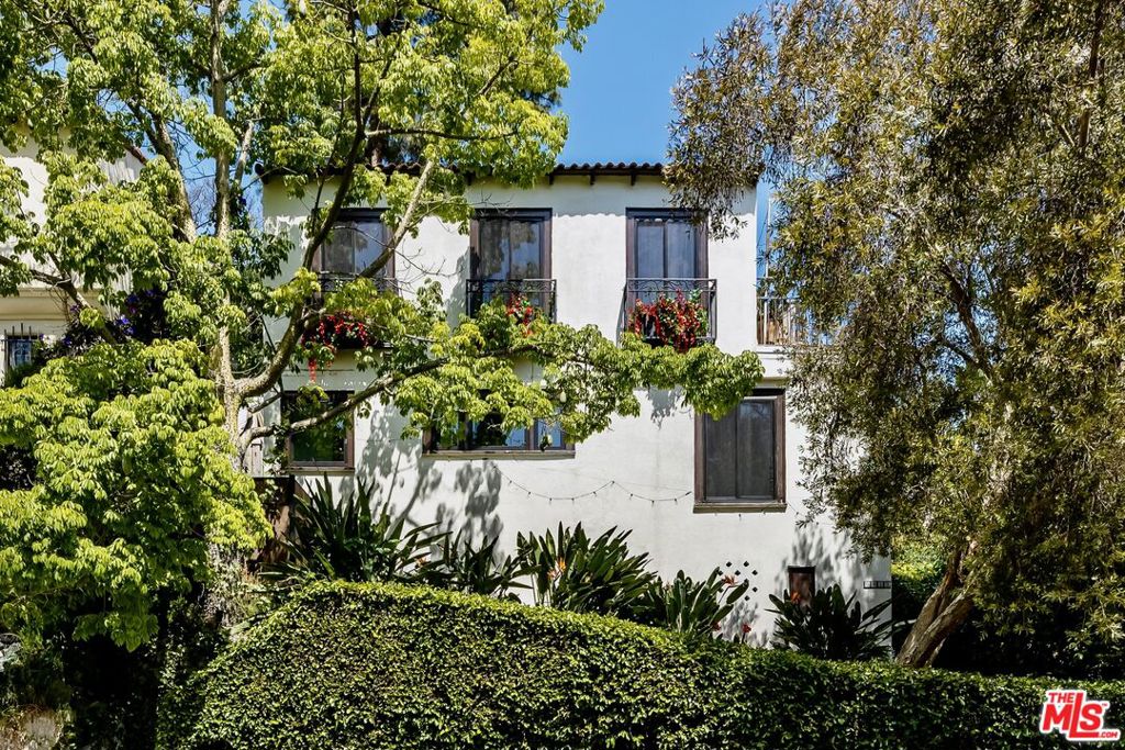 Welcome to this beautifully reimagined two-story Spanish in the heart of the Hollywood Hills. Full of character, natural light, and modern updates, this home combines timeless charm with today's functionalityplus a brand-new ADU for income potential, guests, or creative space.Step inside and you're greeted by large windows and an inviting flow. To the left, a recently updated kitchen features stone counters, re-engineered wood floors, and stainless steel appliances. The adjoining dining area offers views of the hills, creating the perfect backdrop for dinner parties or morning coffee.A stunning staircase with hand-painted Spanish tiles leads to the upper level. Here you'll find the primary suite, complete with an attached bonus room ideal for a home office, nursery, or cozy lounge. The renovated bathroom and guest bedroom both showcase charming beamed ceilings that bring warmth and character.The top-floor living room is a showstoppersoaring beamed ceilings, a dramatic fireplace, walls of windows, and doors that open to a spacious balcony with panoramic Hollywood Hills views.Downstairs, the newly built ADU (2023) offers its own kitchen, living area with exposed beams, bedroom, and full bath. This versatile space has its own private entrance and even connects to a generous basement that can serve as storage, a reading nook, or an office.Out back, you'll find an intimate outdoor area with just enough room for entertaining without the upkeep of a large yard.This is a rare opportunity to own a quintessential Hollywood Hills home with income-producing potential, modern updates, and timeless Spanish charm.