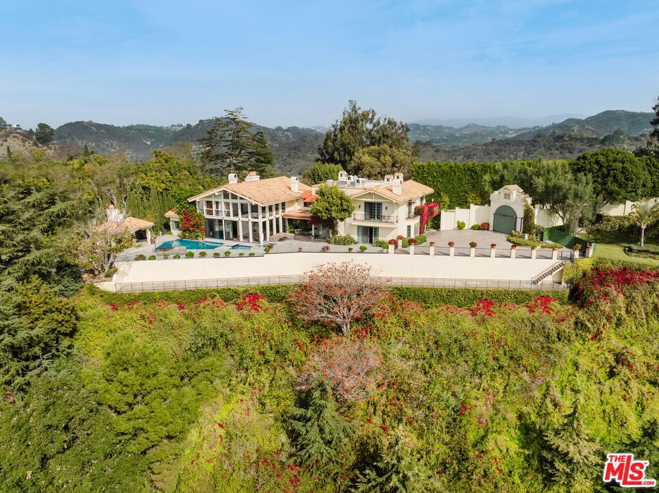 Set atop a prime Bel Air hilltop, this classic estate offers a serene escape with unobstructed ocean, city, and canyon views. The home blends mid-century charm with timeless appeal. The light-filled residence features spacious, well-appointed living areas, including a formal dining room, family room, and a vast bonus room perfect for entertainment. Hardwood floors flow throughout, enhancing the home's elegant atmosphere. The gourmet kitchen, complete with a sunny breakfast nook, is ideal for gatherings. Four bedrooms, including a luxurious master suite with a marble bath, offer comfort and privacy. Smart home capabilities, multiple fireplaces, and a two-car garage complete the offerings. This estate is the epitome of refined living in Bel Air. Set behind the prestigious East Gate of Bel Air, this ultra-private Mediterranean estate offers breathtaking, unobstructed views of the ocean, city skyline, and canyon. Spanning 7,500 square feet, the home is a sanctuary of light and space, designed for both grand entertaining and intimate living. A soaring two-story wall of windows defines the expansive main living and dining areas, flooding the interiors with natural light. The newly renovated chef's kitchen, complete with a sunlit breakfast area, is equipped for everything from casual meals to large-scale gatherings. A wine closet, guest suite, and two powder rooms complete this level. Upstairs, the primary suite is a retreat unto itself, featuring a sitting area with a fireplace, an oversized walk-in closet, and a spa-like bathroom. Three additional bedrooms, each with en-suite baths, offer comfort and privacy. A dedicated fitness room and a separate maid's quarters with a kitchenette and private entrance enhance the home's functionality. Designed for seamless indoor-outdoor living, the exterior showcases a shimmering pool and spa, a spacious viewing deck, and a covered outdoor dining area with a built-in BBQ, perfect for entertaining against a stunning backdrop. Fully gated and secure, this estate offers the utmost privacy in one of Los Angeles' most coveted enclaves, making it a rare and prestigious offering.