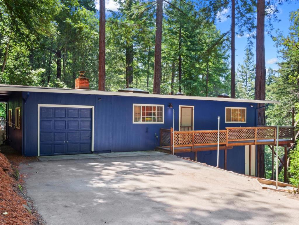 Located in the majestic redwoods of Felton, 11660 Edgewood Dr is a peaceful mountain retreat offering unmatched privacy, scenic views, and a rare sense of tranquility. Set on a double lot, this 2-bedroom, 1-bathroom home features 770 sq ft on a single level of thoughtfully designed living space with a cozy and inviting layout that is easy to maintain. Inside, you will find a charming wood-burning fireplace, laminate flooring, quartz kitchen countertops, and skylights that invite in natural light and warmth. Expansive balconies run the length of the home; perfect for enjoying your morning coffee among the trees or gathering with friends for sunset views. Enjoy the redwood grove situated at the front of this property, contributing to the surrounding peaceful environment of the home The attached garage and generous parking area provide room for guests, recreational vehicles, or additional storage. Whether you're cozying up by the fire or heading out for a day of hiking and biking, this home invites you to slow down and embrace nature. Loch Lomond and local parks are minutes away, with convenient access to Santa Cruz and Silicon Valley. Sale includes additional parcel, APN#075-351-07
