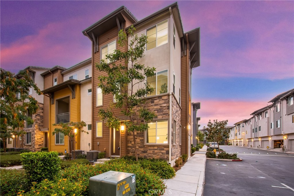 Welcome to 747 Savi Dr #104, a stunning tri-level end-unit townhome in the highly desirable gated community of Boardwalk in Corona! Built in 2019 and impeccably maintained, this 3-bedroom, 2 full bath, 2 half bath home offers 1,675 sq ft of stylish, functional living space. The first floor features a versatile bonus room, a convenient half bath, and direct access to a 2-car garage. Upstairs, the second level boasts a bright open-concept layout with a spacious living room, dining area, a sleek kitchen with a large island, private balcony, and another half bath—perfect for entertaining. On the top floor, you’ll find two well-sized secondary bedrooms, a full hallway bath, and a luxurious primary suite with its own spa-like bath and generous closet space. Residents enjoy access to resort-style amenities including a sparkling pool and spa, BBQ area, tot lot, and dog-friendly green spaces. Ideally located near the 15 and 91 freeways, Metrolink, Cresta Verde Golf Course, and top-rated schools, this commuter-friendly home blends comfort, convenience, and modern living in one perfect package—don’t miss your chance to make it yours!