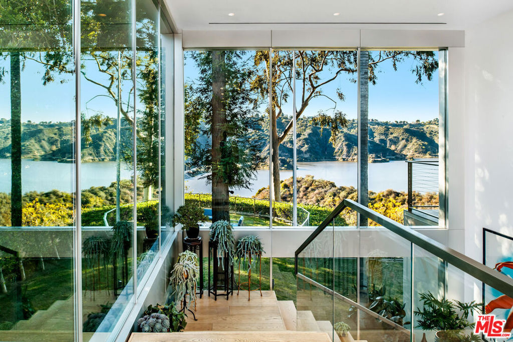 A Rare Jewel at the Pinnacle of Bel AirPerched at the very top of Bel Air Road, this extraordinary 2+ acres of usable land. The property offers breathtaking 180-degree views of the serene reservoir, canyon, city, and beyond. A true private oasis, this estate presents a rare opportunity to create an unrivaled luxury compound in one of Bel Air's most coveted locations.Indulge in a one-of-a-kind retreat at this grand Lake Como-inspired sanctuary, nestled along the tranquil shores of Stone Canyon Reservoir. This architectural masterpiece seamlessly integrates with its natural surroundings, boasting 6 bedrooms and 8 baths across a stunning modern design.Step through the gates to an awe-inspiring floating second floor, illuminated by cantilevered lighting that highlights the dramatic tree-lined hillside perch and shimmering lake below. Inside, a striking floating staircase and expansive skylight welcome you with breathtaking panoramic vistas at every turn.The step-down living room, framed by floor-to-ceiling glass walls, offers the ultimate indoor-outdoor living experience. A bold onyx fireplace serves as a statement divider between the formal dining area and the living room. Upstairs, each bedroom features a private walk-out balcony, while the master suite is a sun-drenched sanctuary with floor-to-ceiling windows, a private terrace, and a room off master that is a perfect office/gym space or can be used as another bedroom.Designed for both comfort and security, the home is equipped with a reverse osmosis filtration system, an XL Generac generator, a state-of-the-art security system with cameras and motion sensors, salt water pool/jacuzzi and a Tesla Starlink system.This is an unparalleled masterpiecea once-in-a-lifetime opportunity to own one of Bel Air's most exquisite properties.