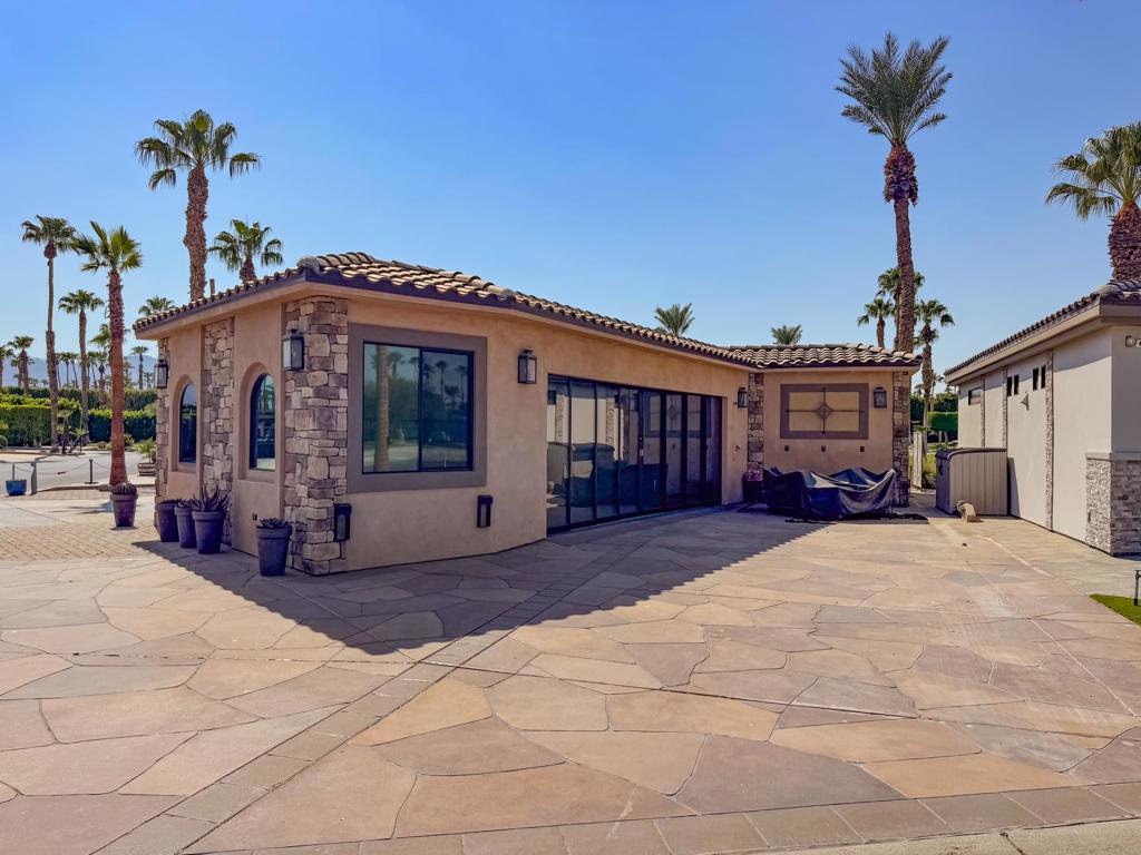 This pitched-roof casita boasts high ceilings, tile flooring, and a spacious gourmet kitchen with custom cabinetry, black leather granite countertops, full-size KitchenAid appliances, and a large island with seating for six. A separate coffee and beverage counter sits conveniently near the walk-in pantry/storage area, which features custom doors with glass inserts. A full glass dining table with seating for six completes this inviting kitchen space.In the living area, a natural stone wall and mantle frame the fireplace, and provides a home for a large screen TV. Opposite this, a built-in wine rack sits above a matching storage cabinet topped with black granite, designed to compliment the kitchen area. Sideways sliding sunscreens and abundant storage can be found throughout.Behind custom barn doors you will enjoy the spa-inspired bathroom including a full-tile steam shower with a glass enclosure, while a private office offers a quiet space to work from home.Offered fully furnished, this rare property allows you to move right in and enjoy a thoughtfully crafted casita in a prime location--just steps from the clubhouse--with an exceptional view. Air conditioning allows you the choice to extend the season at Outdoor Resort Indio. Casita size: 882 sq. ft. (according to blue print). Lot size: 3049 sq. ft.‍Outdoor Resort Indio is a class A RV resort in Indio, California.
