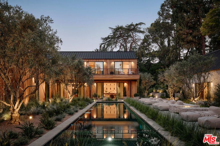 Tucked away within one of Los Angeles' most exclusive, celebrity-studded enclaves of Fryman Canyon, sits a private estate that redefines California living. Designed by AD-published visionary design firm, Studio Rob Diaz. Envisioned in the spirit of the Swedish countryside and inspired by its natural setting, lies a sculptural composition of striking A-frame volumes, cladded harmoniously in wire-brushed cedar. Monumental and inviting, the architecture harmonizes seamlessly with its serene surroundings, where century old redwoods and natural rolling hillsides create a back canvas that only this 1.4 acre estate can offer. Perfectly symmetrical in form, expansive living spaces are defined by soaring 30 foot ceilings in which custom Belgian oak floors, hand finished wall paneling, titanium travertine, copper accents and bespoke lighting, layer this home with warmth and refinement. Thoughtfully compartmentalized, the home balances intimacy with scale, offering seven bedroom suites and eleven baths across multiple forms, each designed with intention and cohesiveness. At the heart of the property is a resort-like pool, grounded by sweeping meadows and limestone decking. Flanking the rear of property are two bespoke Limestone pavilions: one dedicated to wellness with a spa, cold plunge, grand sauna and massage suite; the other a state-of-the-art fitness studio. Nestled between the pavilions, an outdoor kitchen and dining area create the ideal setting for effortless entertaining, while expansive upper decks frame breathtaking vistas of the organic landscape. From its striking architectural pedigree and bespoke materiality, to its unparalleled privacy and connection to nature, the Fryman Estate is a bold statement of design, restraint, lifestyle and legacy; crafted for those who demand the extraordinary.