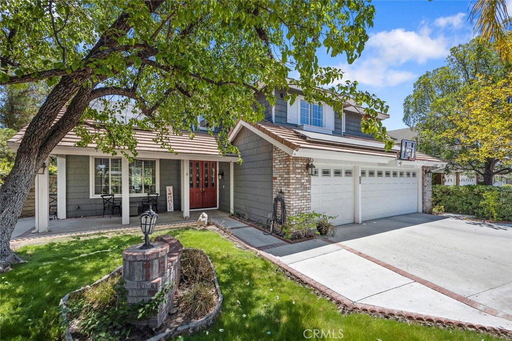 Exquisite Northbridge POOL, SPA and VIEW home on sweeping Flag Lot at the top of a tree lined cul de sac street! This beautifully upgraded two-story home features 4 bedrooms and 3 full bathrooms (one on the MAIN FLOOR) with approximately 2,900 square feet of living space plus a 3-car garage with tons of storage and epoxy coated flooring! The soaring cathedral ceiling, regal winding staircase and plethora of picture windows offers abundant natural light leaving a lasting impression! With neutral, wide luxury vinyl plank flooring, recessed lighting and designer finishes this Valencia home is move-in ready! The bright living room flows seamlessly into the formal dining area, highlighted by large windows and an elegant chandelier! The heart of the home is the beautifully upgraded kitchen featuring a gorgeous, quartz topped center island with bar seating, pendant lights, stainless steel appliances and open glass cabinetry! The kitchen conveniently opens to the spacious and inviting family room complete with a brick fireplace, timeless wood mantle, crown molding, and ceiling fan! This main living space overlooks the sparkling swimming pool, covered patio and built-in BBQ! The main floor also boasts a huge downstairs bedroom and bath with a walk in shower! Tastefully upgraded with pebble like flooring, glass accents and designer lighting! Adjacent there is a convenient laundry room complete with utility sink and extra storage leading to the 3 car garage! The entertainer’s backyard is a true retreat with a sparkling pool and spa, cascading waterfall, covered patio, and a 6-person stone bar complete with built-in BBQ, refrigerator, and brick pizza oven/smoker! With no rear neighbors, this space offers exceptional privacy for gatherings and outdoor fun! Upstairs, the expansive primary suite boasts a double-sided fireplace, views, media niche, walk-in closet, and a spa-like bathroom with dual vanities, pedestal tub, and a floor-to-ceiling glass shower! The Two additional upstairs bedrooms share a spacious hall bathroom with dual sinks, granite countertops, and separate tub/shower combo! Additional highlights include OWNED SOLAR, upgraded lighting, and neutral palette! Valencia Northbridge offers some of the best community amenities in town including pools, tennis courts, playgrounds, and miles of paseos! A short distance to Valencia High School, The Paseo Club, Santa Clarita Trail System and Wolf Creek Brewery! This is a home you’ll cherish for years to come