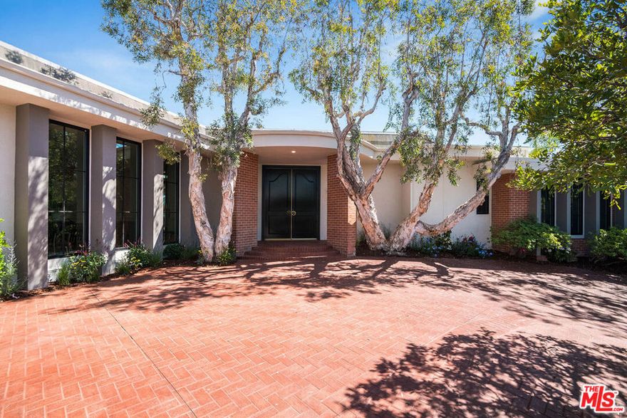 Welcome to "The Scarlett Estate," an extraordinary luxury residence nestled in the prestigious Royal Oaks neighborhood of Encino. This designer-done home offers an unparalleled level of elegance and refinement, combined with breathtaking views that will leave you spellbound. Situated on a peaceful cul-de-sac, this home greets you with a grand entrance that sets the stage for the magnificence that awaits within. Impeccably chosen hand-picked designer fixtures, along with original details, adorn the living spaces, radiating elegance and refinement at every turn. The sheer magnitude of this home is awe-inspiring, featuring massive scale and ceiling heights that create an atmosphere of grandeur. Large windows and custom skylights bathe the interiors in natural light, illuminating the exquisite stone fireplaces featured in both the living room and den. Indulge your culinary desires in the custom kitchen, a true masterpiece that seamlessly combines style and functionality. Equipped with top-of-the-line Thermador appliances, sleek stone countertops, and an exquisite alabaster fixture, it exudes glamour and charm. The adjacent formal dining room provides the perfect setting for hosting unforgettable events and creating cherished memories. Walk down the hallway adorned with five skylights to the primary bedroom, where a fireplace adorned with intricate fluted details becomes the centerpiece, exuding an aura of comfort and luxury. The entirely custom closet is an organizer's dream, and the doors leading to the sparkling pool offer a serene and relaxing atmosphere. Outside, a fully tiled pool beckons for a refreshing swim, while the spa featuring a soothing fountain provides the perfect place to sit and take in the incredible view. The backyard is rounded out with a grassy yard and outdoor BBQ area, allowing you to savor delicious meals in the company of friends and family. This luxurious residence is truly tailored to the most discerning buyers who appreciate the finer things in life. Immerse yourself in the unparalleled craftsmanship, exquisite finishes, and meticulous attention to detail that define this home. Experience the epitome of luxury living at "The Scarlett Estate."