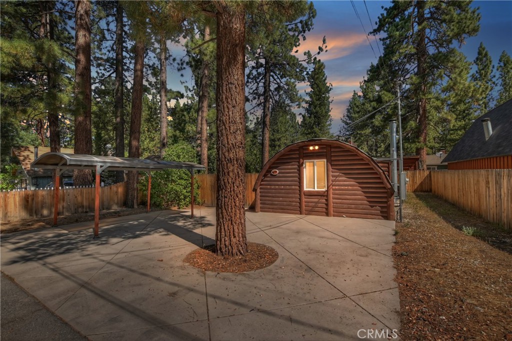 Rustic elegance meets modern comfort at this distinctive quonset retreat in Big Bear City ~ Step into mountain living reimagined with this exquisite 2-bedroom, 2-bath Quonset home ~ A rare architectural gem wrapped in rich log siding and meticulously maintained inside and out ~ Designed for both style and comfort, this residence offers a seamless blend of rustic charm and refined finishes, making it an ideal full-time haven, weekend escape, or premium short-term rental ~ The light-filled open floor plan showcases soaring tongue-and-groove ceilings, creating a warm yet airy ambiance ~ The gourmet kitchen is a showpiece with handcrafted custom cabinetry, sleek Corian countertops, and thoughtful design details that make both everyday living and entertaining a pleasure ~ Luxurious heated floors in the bathrooms add a touch of spa-like indulgence, perfect after a day on the slopes ~ Enjoy the outdoors year-round with a welcoming private front porch, a sheltered back porch for relaxed gatherings, and a generous double shed for all your mountain gear ~ Ample parking—including a carport—ensures effortless convenience ~ Set in a prime location, you’re just a short stroll to Snow Play and Oktoberfest festivities, and a quick 5-minute drive to the lake, scenic hiking trails, world-class ski slopes, and vibrant dining ~ Here, every day feels like a getaway.