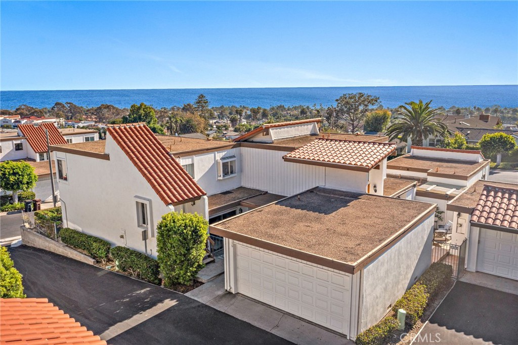 Enjoy panoramic ocean views from Dana Point Harbor all the way to Cottons Point! Discover the best of San Clemente in this beautifully updated 3-bedroom, 2.5-bathroom townhome located in the highly sought-after Ocean Hills community. The main living area is positioned upstairs to maximize ocean views, featuring an open-concept living and dining space that flows seamlessly to a spacious balcony—perfect for entertaining or enjoying stunning sunsets. The light-filled kitchen boasts crisp white cabinetry, stainless steel appliances, a wine fridge, and abundant natural light. Freshly painted interiors and new luxury vinyl flooring throughout create a clean, modern coastal aesthetic. Downstairs, two guest bedrooms share a full bath, with one offering direct access to a private ocean-view patio—a tranquil retreat to savor the coastal breeze. The primary suite features its own ensuite bath and opens to a serene courtyard patio, located between the home and detached two-car garage, which includes laundry. Residents of Ocean Hills enjoy resort-style amenities including two swimming pools, a 9-hole chip-and-putt golf course, and a premier location moments from shopping, dining, Trader Joe’s, and Starbucks. With the beach, pier, and downtown San Clemente just a short drive away, this home offers the ideal blend of style, comfort, and coastal charm.