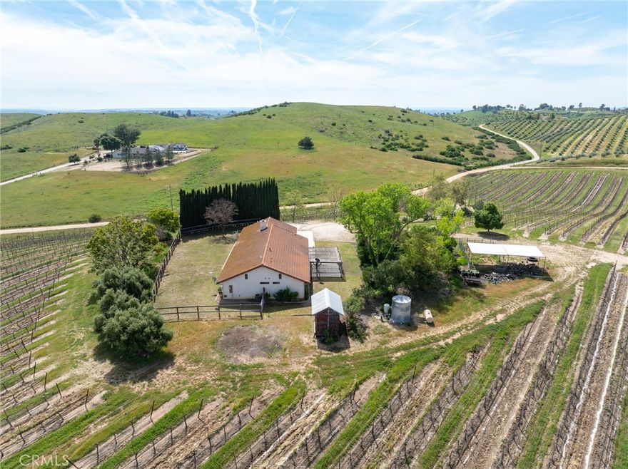Enjoy the best of Paso Robles wine country living with this peaceful and private 14-acre property, offering scenic views and relaxed rural charm. The 1,902± sq.ft. single-level home features 4 bedrooms, 2 bathrooms, and a bonus room—perfect as a home office, guest space, or hobby room. The open floor plan includes a spacious kitchen with ample storage, a welcoming dining area, and a cozy living room with a wood-burning fireplace and large windows that frame breathtaking vineyard and valley views.
Professionally managed and low-maintenance, the 11± acres of premium Cabernet Sauvignon vines offer passive income potential, with an optional grape contract available through a luxury Napa wine company. Strong projected 2025 crop yields between 4-5 TPA offer great potential income. Enjoy the perks of vineyard ownership without the labor—ideal for investors or those seeking a tranquil home in wine country. 
The setting is serene and inspiring, surrounded by lovely neighbors including a lavender farm, equestrian ranch, olive grove, and fruit orchard. The property offers abundant space for animals, gardens, and future expansion—whether you envision an additional home, ADU, or workshop. Interested in removing some or all of the vineyard? No problem!
Vacation rental and 1031 exchange eligible, this is a rare opportunity to own a turnkey vineyard lifestyle property in a desirable Paso Robles location.