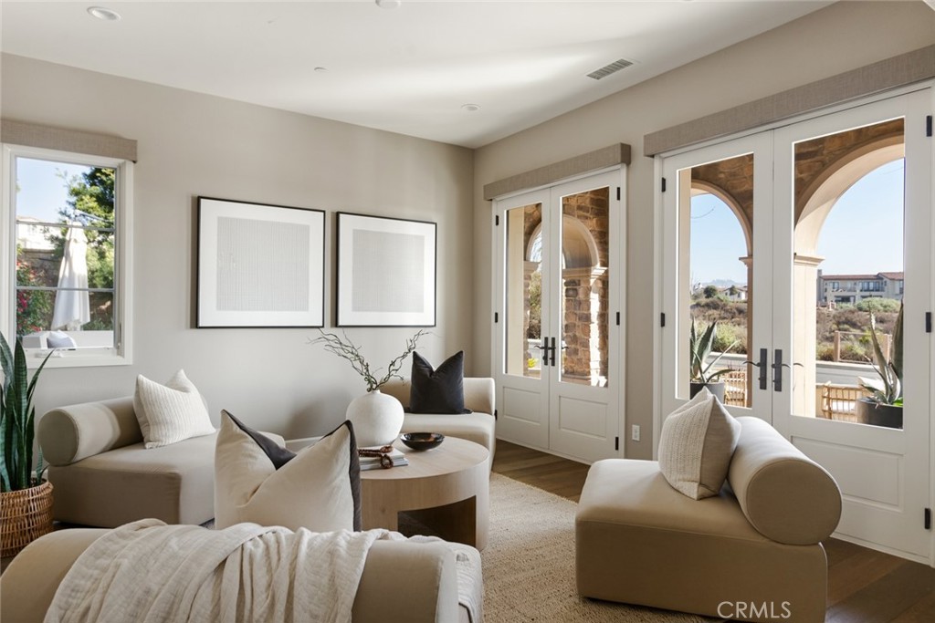 Life by the ocean is elevated to an impressive new level of luxury at this exquisitely appointed Azure home at Sea Summit in San Clemente. Beautiful ocean and canyon views are enjoyed from both levels of the residence and its welcoming front patio with built-in seating and an open-air fireplace. Romantic architecture with stone accents and dramatic archways is embellished with drought-tolerant native landscaping and custom hardscaping on grounds that extend approximately 9,228 square feet. The sought-after corner homesite reveals a side patio with built-in seating, a private interior courtyard with fireplace, a sport court, and a resort-style backyard with infinity-edge spa, elevated deck with fire pit, a heated loggia with wood-plank ceiling, and a custom kitchen with grill, sink, refrigerator and bar. Interior spaces are sublime, with a soft-contemporary aesthetic that complements open living areas, a double-height foyer with arched entry door, four ensuite bedrooms, a loft and five baths. Approximately 4,244 square feet, the comfortably sized design showcases a formal living room with two sets of French doors opening to the front patio, a formal dining room with walls of glass doors leading to the courtyard and backyard, and a main-level guest suite with backyard access. The dining room flows effortlessly to the family room, where a fireplace, surround sound, and glass doors opening to the loggia are displayed. The kitchen is a masterpiece of fashion and function, blending top-of-the-line Wolf and Sub-Zero appliances with on-trend stone countertops, Shaker cabinetry, a large island with seating, butler’s pantry, stainless steel apron sink, and designer tile backsplash. Numerous windows illuminate the home with natural light that accentuates wood flooring, premium carpet, custom paint and wall treatments, sophisticated LED lighting fixtures, ceiling fans, built-in cabinetry throughout, and Juliet balconies in many rooms. Enjoy romantic ocean views from the deck off a primary suite that hosts an oversized walk-in closet with built-ins, a soaking tub and spacious shower. Solar power, an expansive laundry room and a two-car garage are also featured. Sea Summit is nestled along oceanfront bluffs and presents scenic trails, beach access, preserved canyons and open space, five community parks, and a lux clubhouse with pool, spa, gym and lounge areas. Restaurants and shops are moments from home at Outlets at San Clemente, and award-winning schools are nearby.