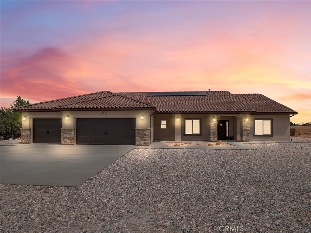 Welcome to this custom-built home in the South foothills of Phelan, less than 1.5 miles from schools and shopping, with breathtaking mountain views and convenient access to the paved intersection of Johnson Rd. and Neilson Rd. Built in 2024 and nestled on a spacious lot in Snowline School District, this home combines thoughtful craftsmanship with energy efficiency and modern comforts. Inside, you’ll find a bright open-concept floor plan with a breakfast nook, formal dining area, and a chef’s kitchen featuring a commercial style Z-Line 36” 6-burner gas range with electric convection oven, stainless steel appliances, Ashwood shaker cabinets with soft-close drawers, and sleek quartz countertops. A large pantry adds extra storage. The living area is anchored by a custom wood-burning stove with a flat rock hearth, creating the perfect spot to gather on cool winter nights. The private master suite is a retreat of its own, complete with a soaking tub, tiled shower, toilet room, walk-in closet, and access to its own 27x15 covered patio. Two additional bedrooms offer comfort with carpeted flooring, while the rest of the home features durable custom tile and flat black fixtures for a modern touch. Designed with efficiency in mind, this property includes paid off solar panels, an owned propane tank, a Culligan water softener, RO drinking water system, tankless water heater, upgraded stylish prohibition era wood grain weather resistant front door, and full-perimeter gutters draining into underground drainage. Cooling and airflow are enhanced with ceiling fans throughout. Outdoor living is a highlight with a 15x50 covered back patio off the living room, complete with propane connection for a grill or outdoor kitchen, making it perfect for entertaining. The 3-car garage is oversized at 835 sq. ft., with insulated doors, LED lighting, and ample storage. With its terra-cotta tile roof, custom stonework, and high-end finishes inside and out, this home is truly move-in ready—offering peace, privacy, and timeless style in a neighborhood of other custom homes.
