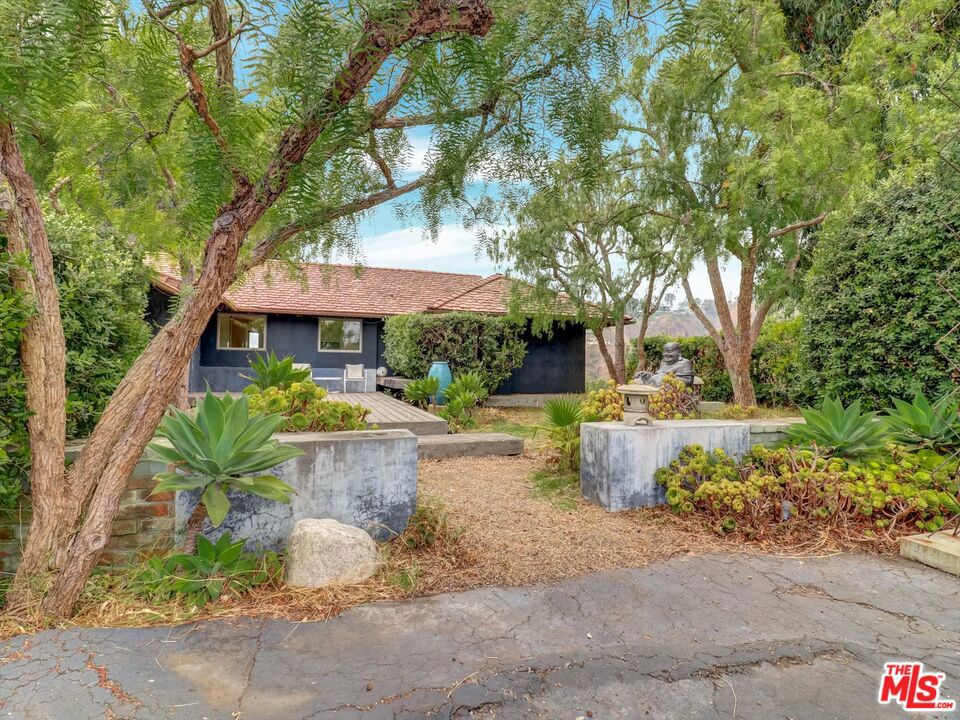 Perched atop its own private knoll, this mid-century modern home offers breathtaking, panoramic views of the Santa Monica Bay and coastline that stretch endlessly beyond. Floor-to-ceiling windows bathe every room in natural light, creating a seamless connection to the surrounding landscape while maintaining a rare sense of privacy.Inside, the home showcases thoughtful design and unique architectural details. The primary suite is a retreat in itself, featuring a spa-inspired bathroom designed for ultimate relaxation. A hidden doorway reveals an expansive guest suite, ideal for hosting family, friends, or creating a private office or creative studio.With its elevated setting, timeless design, and distinctive features, this residence is a true architectural gemcombining the best of mid-century modern living with an unparalleled location.