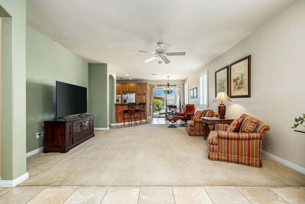 Welcome to this beautifully maintained San Ysidro model in the gated 55+ community of Sun City Shadow Hills. OFFERED TURNKEY-FURNISHED, this 2-bedroom + Den, 2-bath home offers 1,463 sq. ft. of comfortable living. The bright, open layout features high ceilings, PLANTATION WOOD SHUTTERS, 16' tile flooring in all areas except great room, den, and bedrooms. The well-appointed kitchen includes granite countertops, double ovens, a gas cooktop and a stainless steel refrigerator. A laundry room with sink adds convenience. The primary suite offers a spacious bath, large walk-in shower, and walk-in closet. Enjoy stunning MOUNTAIN VIEWS from the covered patio, surrounded by low-maintenance yard with paver pathway, river rock, and vibrant bougainvillea. Additional features include a NEWER HVAC UNIT w/THERMOSTAT (2 years old), and wall storage cabinet, overhead storage shelves and a workbench in the garage. Enjoy resort-style living with access to golf, pools, fitness centers, social clubs, and more. Live the lifestyle you deserve--schedule your private showing today!