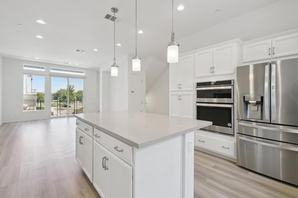 Modern comforts meet everyday functionality in this bright and well-appointed 2-bedroom, 2.5-bath unit perched near the top of Irvines coveted Great Park neighborhood. With unobstructed views and access to all the exceptional amenities the Great Park has to offer, this home blends peaceful surroundings with convenient perks in a beautifully maintained low-rise condo community. The kitchen is a standout, offering plenty of cabinetry, sleek countertops, and built-in stainless steel appliances. An oversized island anchors the space, providing room to prep, dine, or simply gather around. Nearby, the dining area flows into a comfortable living space, filled with natural light and enhanced by wide-plank floors and clean, modern finishes. A glass slider opens to a private outdoor landing, adding a bit of fresh air and scenery to your daily routine. Both bedrooms come with their own baths, and the main bedroom features a spacious layout with a large window, soft carpeting, and a dedicated work area. The ensuite bath includes dual vanities, a step-in shower with a glass enclosure, and generous storage under the counter. Living here means easy access to scenic trails, top-rated schools, and all the amenities of the Great Park - from sports fields to community pools.