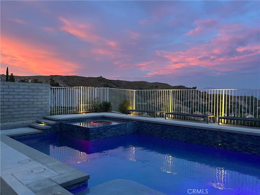 Welcome to your dream home a beautifully designed two-story residence featuring 4 spacious bedrooms and 2.5 baths, including a convenient main-floor bedroom. Soaring vaulted ceilings and a grand staircase greet you as you step inside, setting the tone for elegance and comfort throughout.
The gourmet kitchen boasts a gas stove, dual ovens, a large center island, and plenty of space for entertaining perfect for both intimate dinners and lively gatherings. From the kitchen, dining area, family room, and luxurious master suite, enjoy breathtaking views of the Santa Clarita Valley. 
Relax and unwind in your private backyard oasis, complete with a sparkling swimming pool, spa, and artificial turf for easy maintenance. The master suite features its own private balcony, ideal for morning coffee or evening sunsets. Additional highlights include a solar power system, whole-house water filtration, and location within the highly sought-after William S. Hart School District.