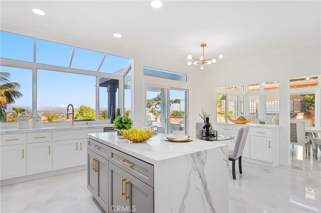 Discover unparalleled coastal living in this meticulously renovated 3-bedroom, 2.5-bathroom home nestled within the prestigious Niguel Summit community of Laguna Niguel. Spanning 2088 square feet, this stunning residence boasts panoramic vistas stretching from Saddleback Mountain to the Pacific Ocean. Step inside to discover a beautifully redesigned interior featuring a cozy fireplace in the family room, complemented by chic lighting fixtures. Just upgraded with new windows, doors, and fresh paint, along with gorgeous porcelain tile floors, the home exudes modern elegance and comfort. The gourmet kitchen is a culinary delight, showcasing quartz countertops, sleek white shaker cabinets adorned with gold hardware, an eat-at island with stylish grey cabinets, and state-of-the-art appliances including a wine fridge. Luxury awaits in the primary suite, complete with a spacious walk-in closet, a sumptuous soaking tub, a separate step-in shower, and dual sinks overlooking scenic vistas. Ideal for entertaining, the newly surfaced pool with a tranquil jacuzzi and water feature beckons relaxation amidst breathtaking views. Additional highlights include two secondary bedrooms with updated glass slider closets, an updated hall bath with a large skylight-lit step-in shower, and luxury vinyl flooring throughout the upstairs for a touch of refinement. Enjoy the ultimate in privacy with a front gated courtyard entry and the convenience of direct access to a 2-car garage and a 2-car driveway. Located on a single loaded street, this home offers serenity and exclusivity in one of Laguna Niguel's most coveted neighborhoods. Perfectly positioned near Monarch Beach, Dana Point Harbor, and the vibrant cultural scene of Laguna Beach, residents will relish easy access to world-class beaches, renowned hiking trails, golf courses, and upscale shopping and dining options. With top-rated schools nearby, this is an exceptional opportunity to experience Southern California coastal living at its finest.