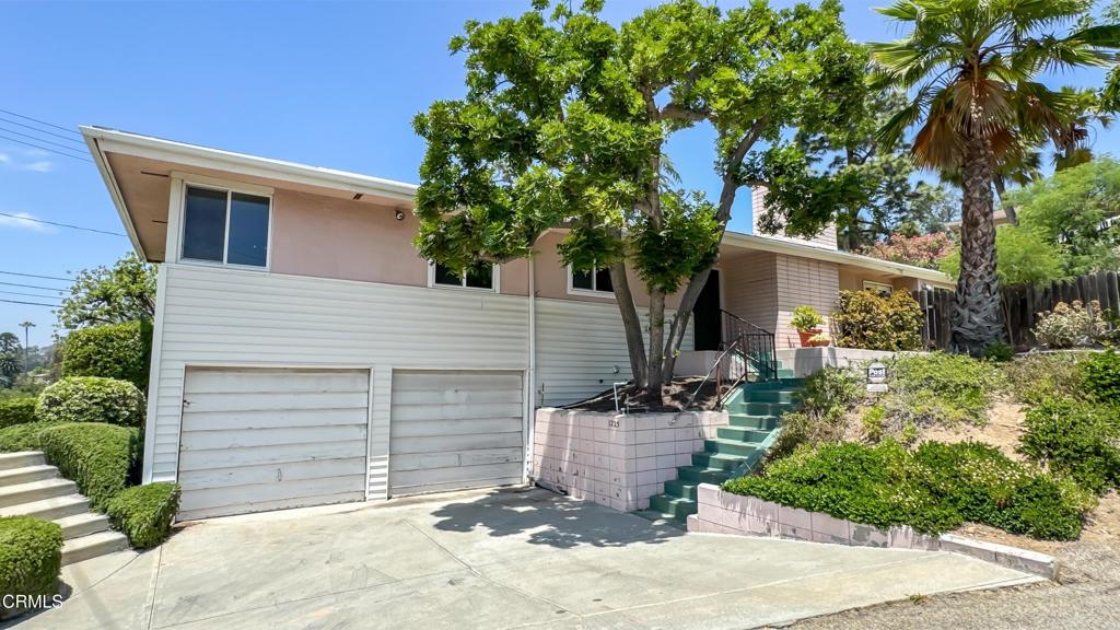 Welcome to 1225 Church Street, a mid-century gem tucked into the quiet hills of Pasadena. This charming 3-bedroom, 2-bathroom home sits proudly on an elevated corner lot, offering sweeping tree-top views and a sense of privacy. The classic horizontal roofline is complemented by terraced landscaping and mature trees. Inside, large picture windows fill the living spaces with natural light and frame views that stretch to downtown Los Angeles. The open layout includes a welcoming living room and a vintage kitchen that retains its original charm. Additional features include an attached two-car garage, generous under-house storage, central heating and air conditioning, updated copper plumbing, and a backyard with potential for entertaining, gardening, or future expansion. Combining timeless style with comfort and seclusion, this is Pasadena hillside living at its finest.