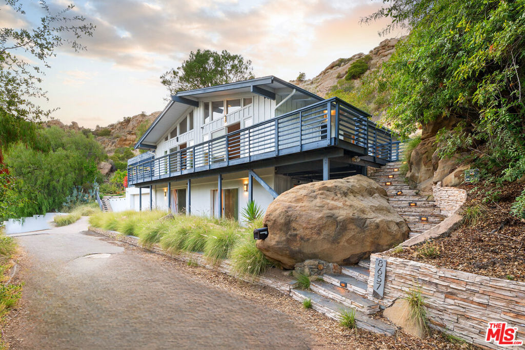 Expansive, double lot totaling over 26,000 square feet with breathtaking views. Set within a picturesque West Hills mountainous landscape, this single-family retreat features 3 bedrooms and 3 bathrooms spread over a generous 2,100 sqft floor plan, offering ample indoor and outdoor space. Upon entering, you're welcomed into a bright living area with vaulted ceilings and a large deck boasting scenic views. Double doors open off the living room to an enormous covered patio. The modern kitchen features sleek countertops, chef-grade appliances, and abundant storage space, catering to any home cook's delight. Two well-appointed main-floor bedrooms offer brightness and space, each with sliding doors accessing an outdoor retreat. Every bathroom boasts modern fixtures and finishes. The downstairs primary bedroom is a serene sanctuary, complete with an ensuite remolded bathroom and multiple walk-in closets. The standout feature of this property is the outdoor oasis featuring multiple outdoor entertainment spaces, lush mature landscaping, canyon views, and an expansive putting green, perfect for golf enthusiasts or those seeking outdoor recreation. Surrounding rock features add charm and privacy, enhancing the natural outdoor beauty. The extra-large lot consists of two separate APNs totaling 26,632 sqft with possibility for an ADU or additional development. A truly unique and rare opportunity to live in a quiet and serene landscape with stunning views. Award-winning and highly coveted private and public schools nearby. Close to many fine shops and restaurants, including Westfield Mall, The Topanga Village, and The Commons at Calabasas. **Available for sale as well**