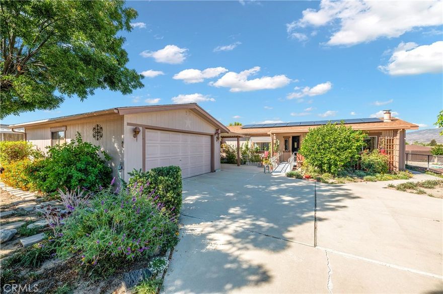 Say hello to charm, space, and views! Located on a quiet cul-de-sac in a peaceful 55+ community, this beautifully maintained home offers warmth, character, and comfort at every turn. The inviting floor plan features vaulted ceilings with wood-beam accents, a cozy brick fireplace, and large picture windows that frame the lush landscaping and mountain views beyond. The cheerful kitchen stands out with abundant cabinet space, double ovens, stainless-steel refrigerator, and a spacious peninsula for easy entertaining. Two generous bedrooms, including a primary suite with an en-suite bath, provide plenty of room for relaxation. Step outside to your enclosed patio — the perfect spot for morning coffee or evening sunsets. The front of the home offers mature trees, colorful flowers, and lovingly cared-for plants. A detached two-car garage adds extra storage and convenience, while the long driveway and low-maintenance yard make this home as functional as it is beautiful. Located in a serene senior community close to shopping, dining, and scenic walking areas, 43678 Pioneer Street blends privacy, charm, and pride of ownership.